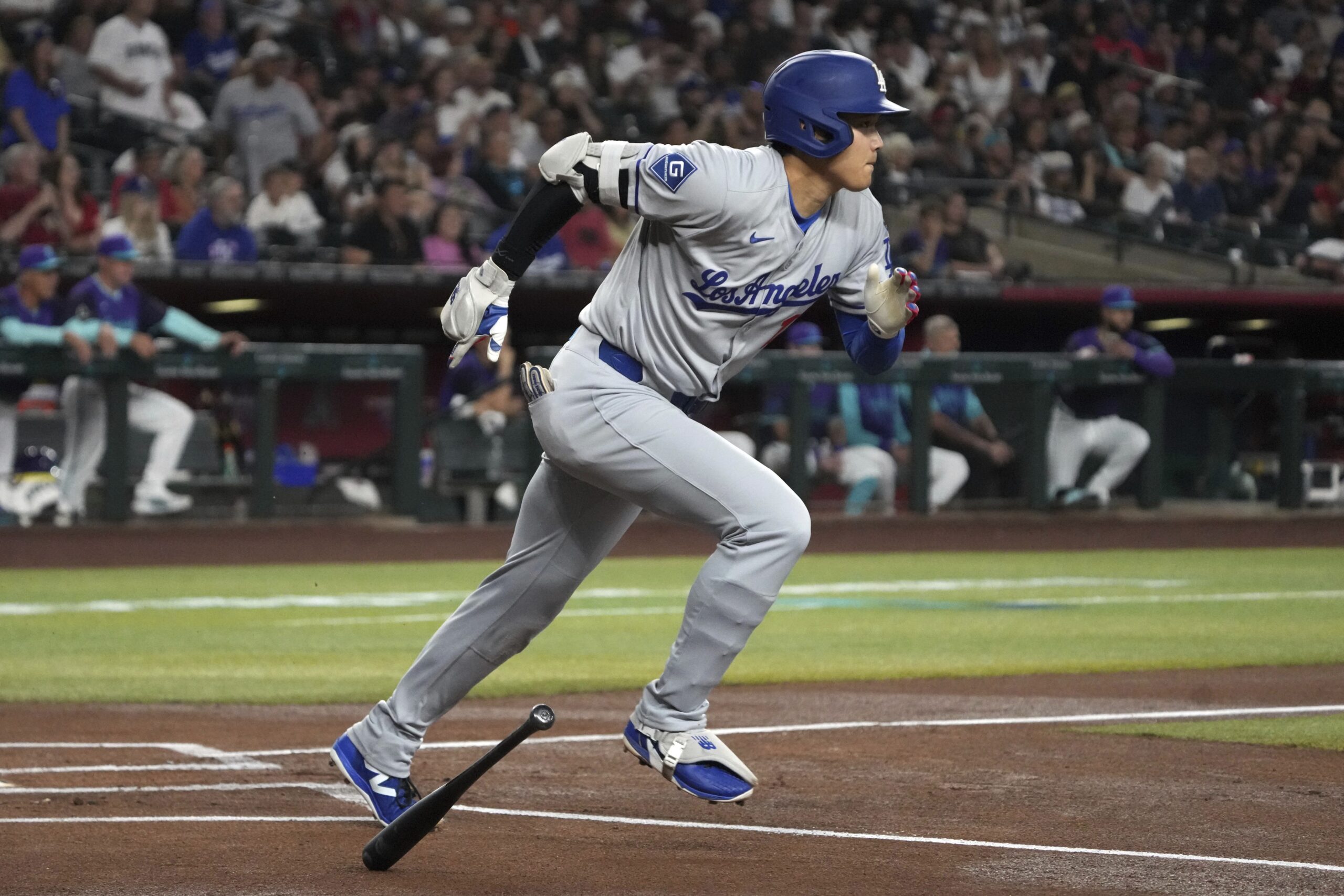 Dodgers’ Shohei Ohtani starts to run after hitting a single...