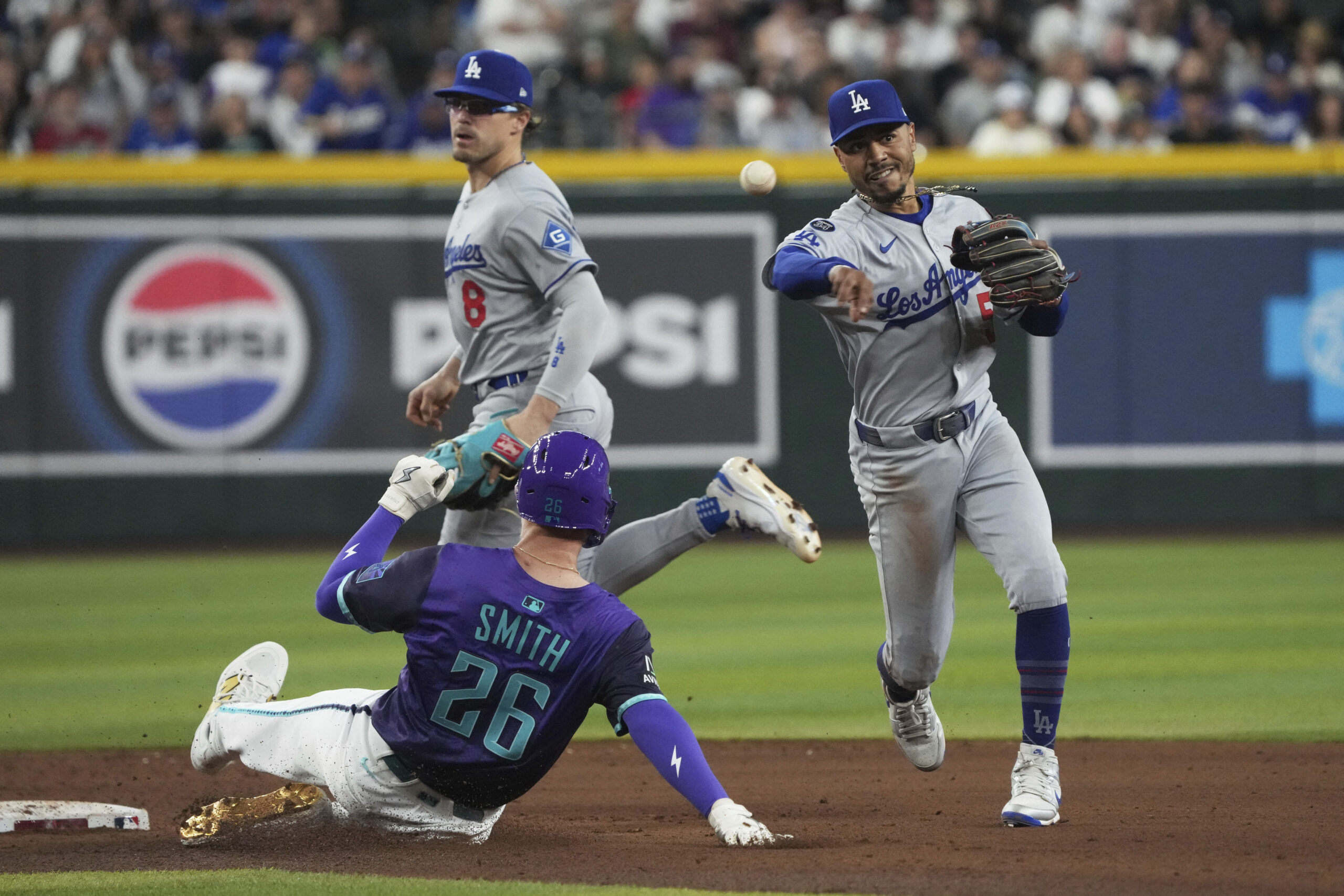 Dodgers shortstop Mookie Betts, right, turns the double play while...