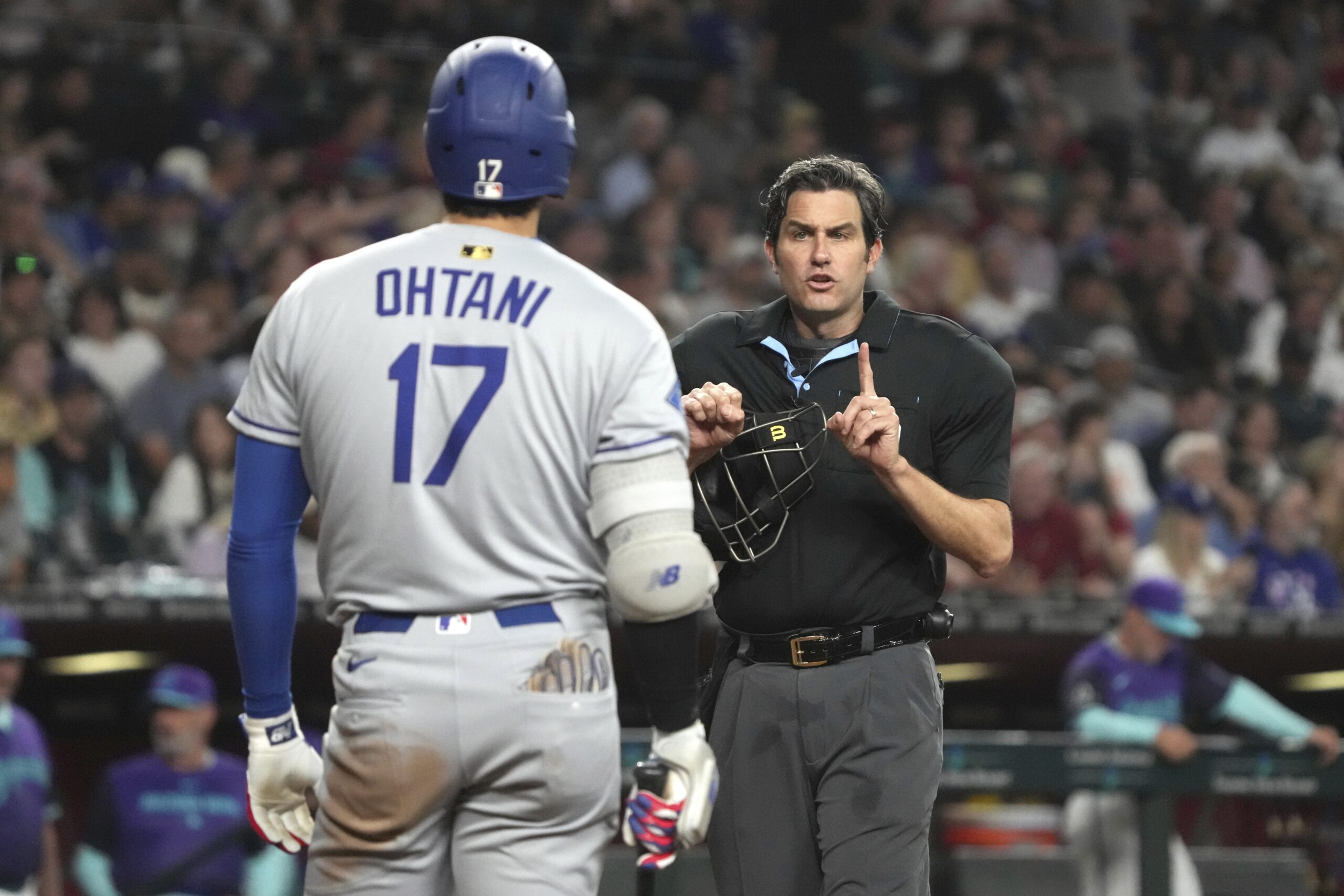 Home plate umpire John Tumpane, right, tells Dodgers’ Shohei Ohtani...