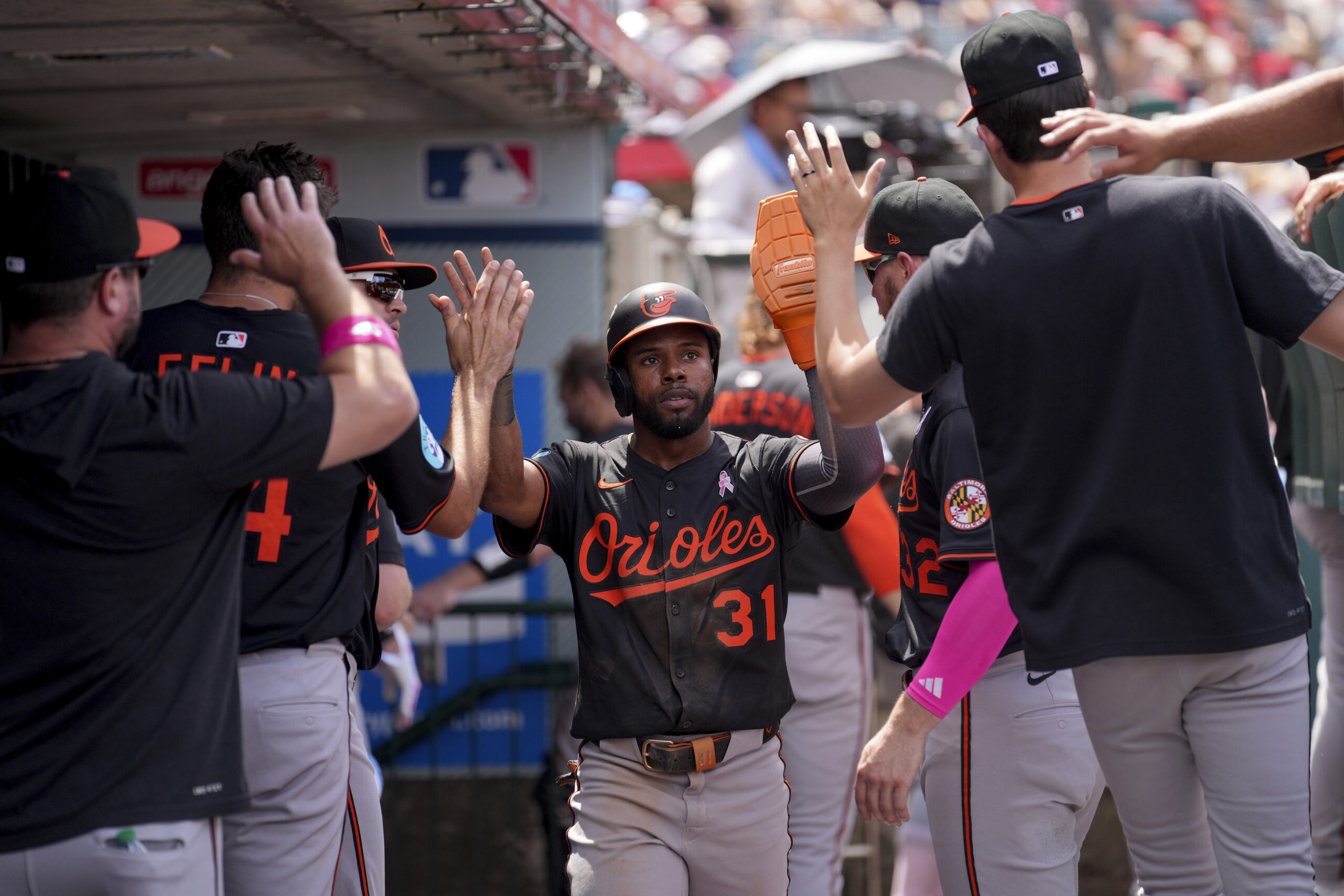 Baltimore Orioles/ Cedric Mullins (31) high-fives teammates after scoring a...