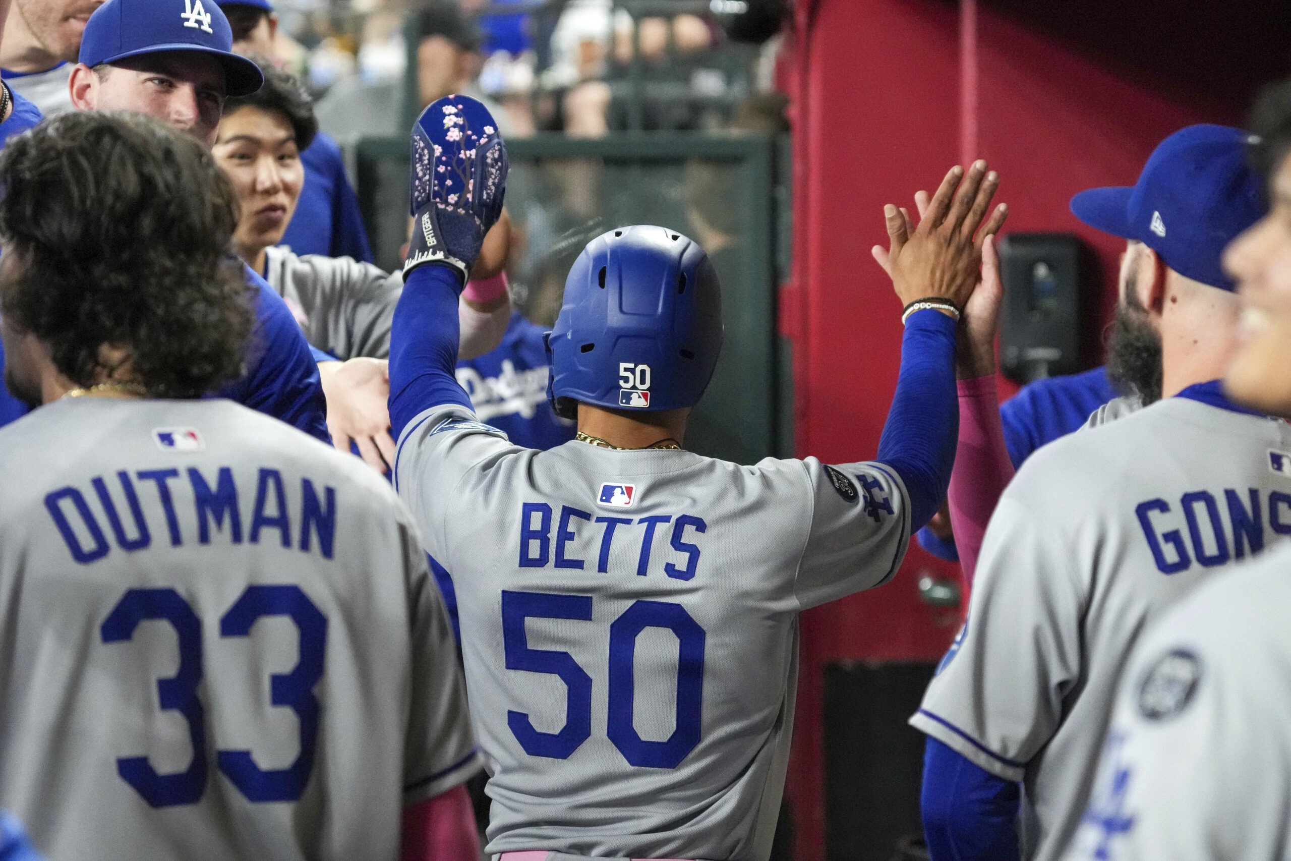 Dodgers shortstop Mookie Betts (50) gets high-fives from teammates after...