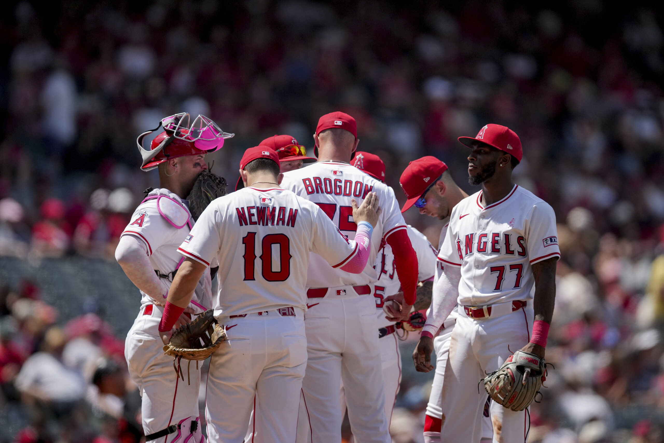 Angels first baseman Kevin Newman (10) pats relief pitcher Connor...