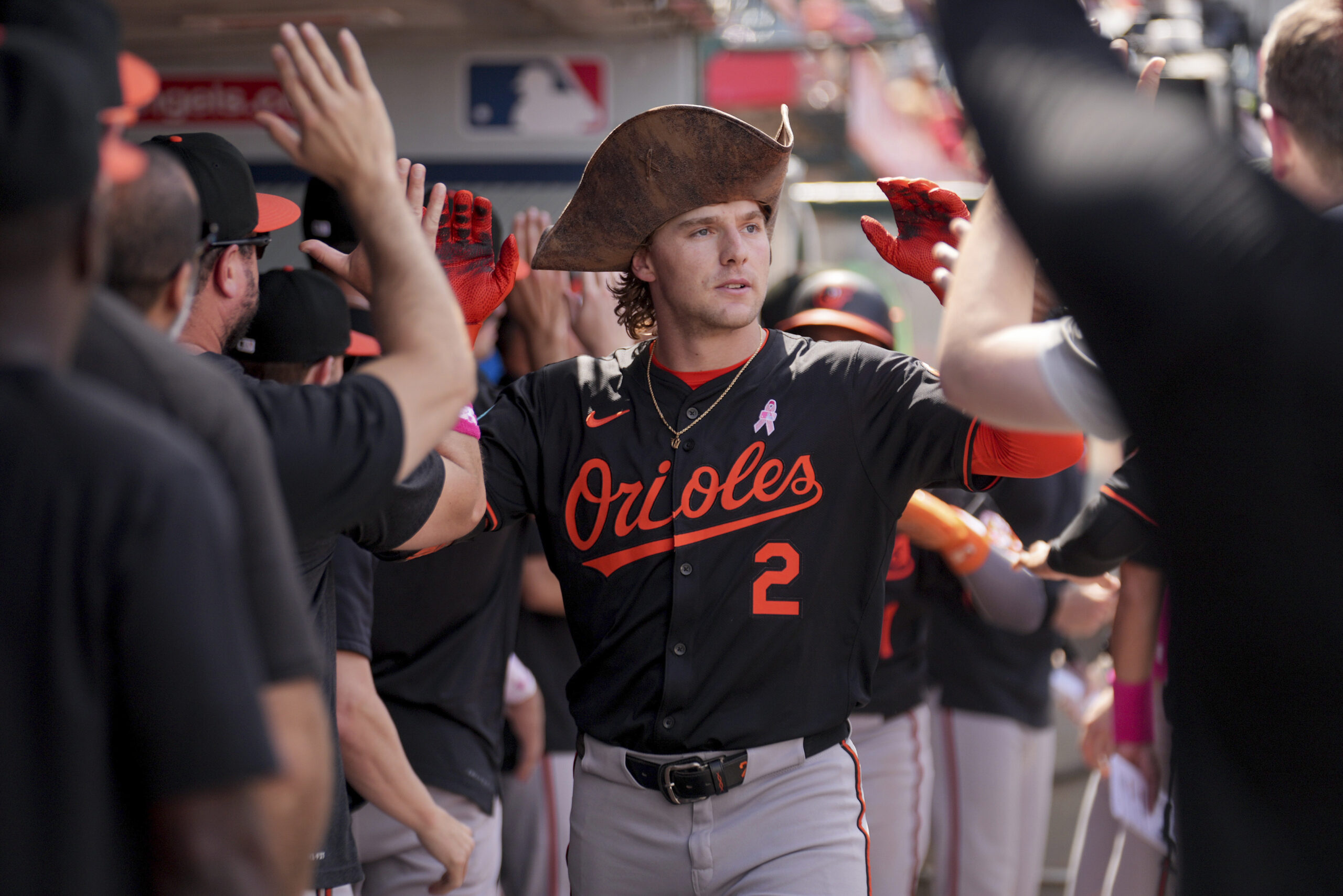Baltimore Orioles’ Gunnar Henderson (2) high-fives teammates in the dugout...
