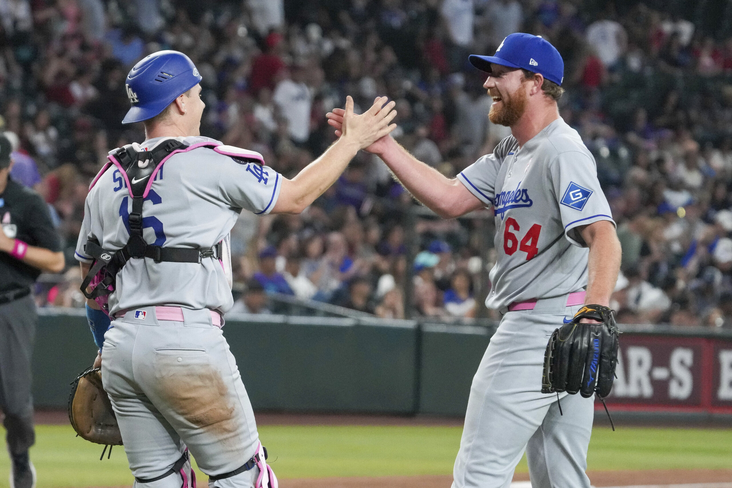 Dodgers catcher Will Smith, left, high-fives pitcher Matt Sauer (64)...