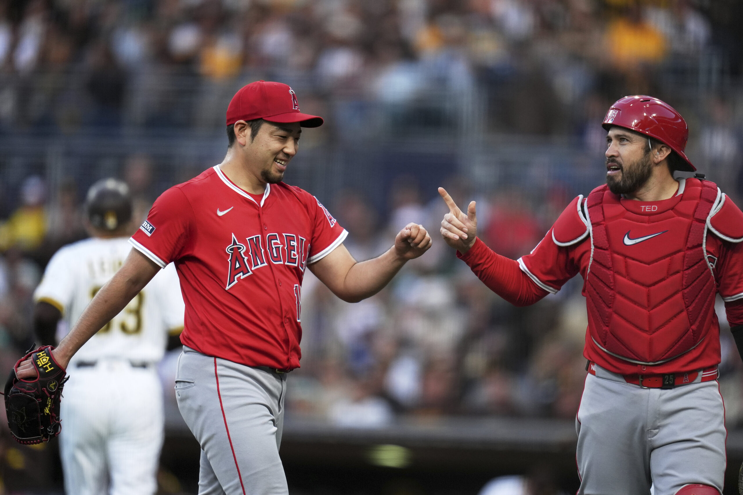 Angels starting pitcher Yusei Kikuchi, left, jokes with catcher Travis...