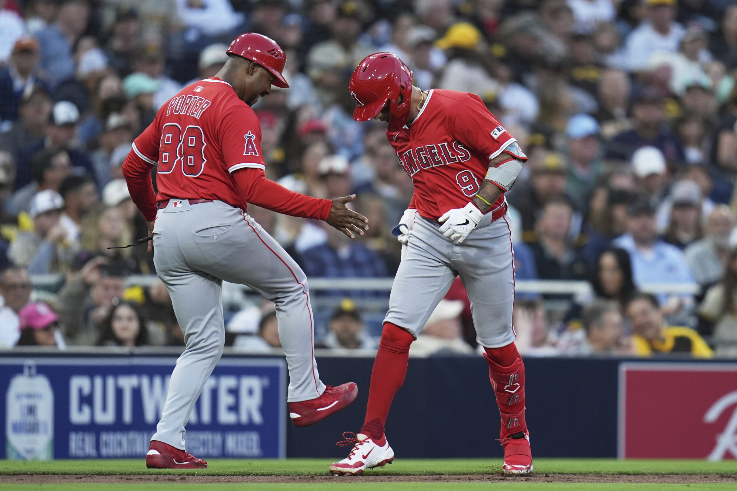 The Angels’ Zach Neto, right, celebrates with third base coach...