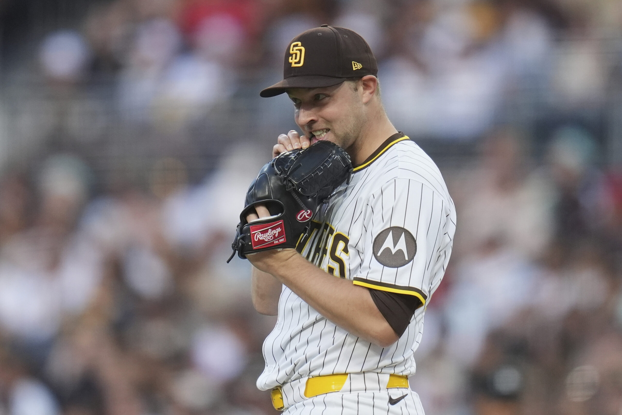San Diego Padres starting pitcher Michael King tightens his glove...