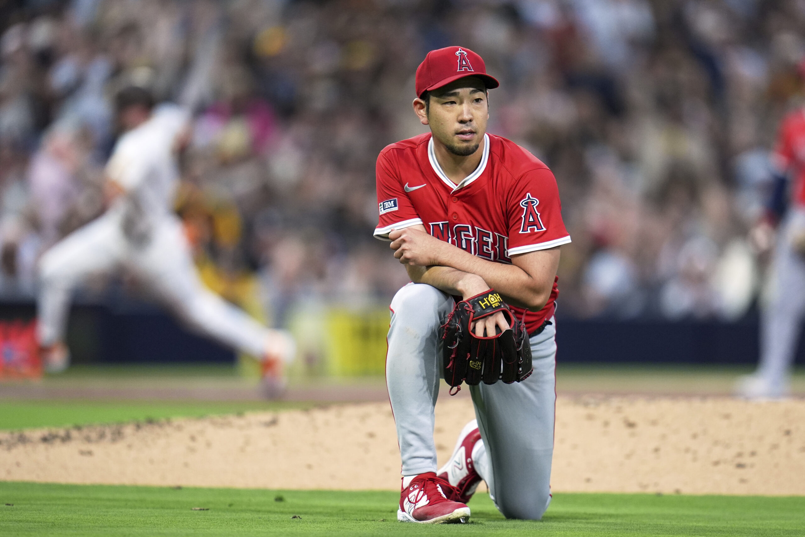 Angels starting pitcher Yusei Kikuchi looks on after overthrowing first...