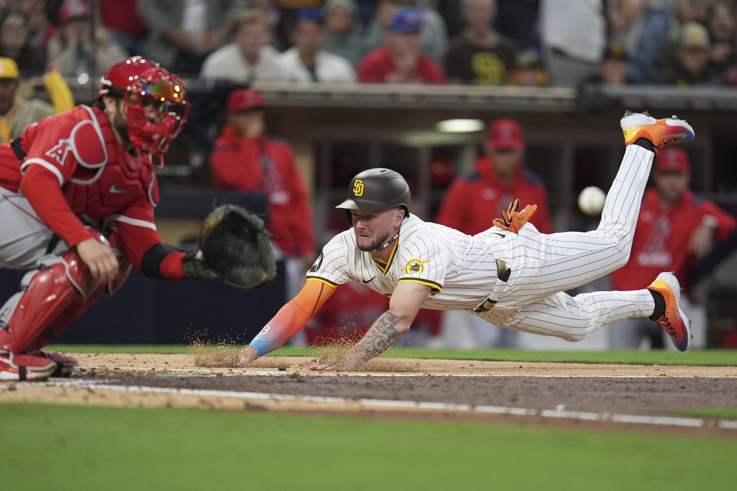 The San Diego Padres’ Jackson Merrill, right, slides into home,...