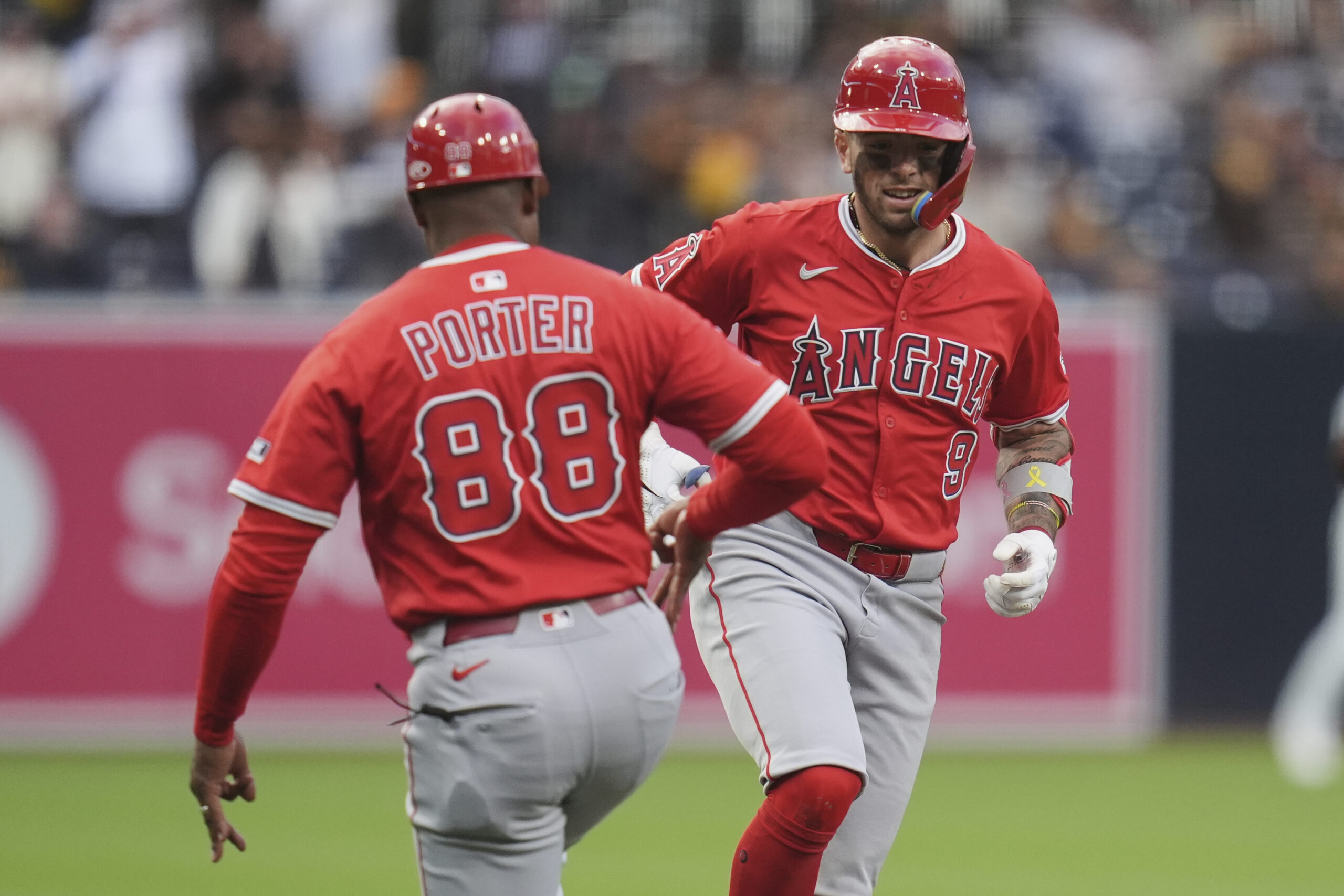 The Angels’ Zach Neto, right, celebrates with third base coach...