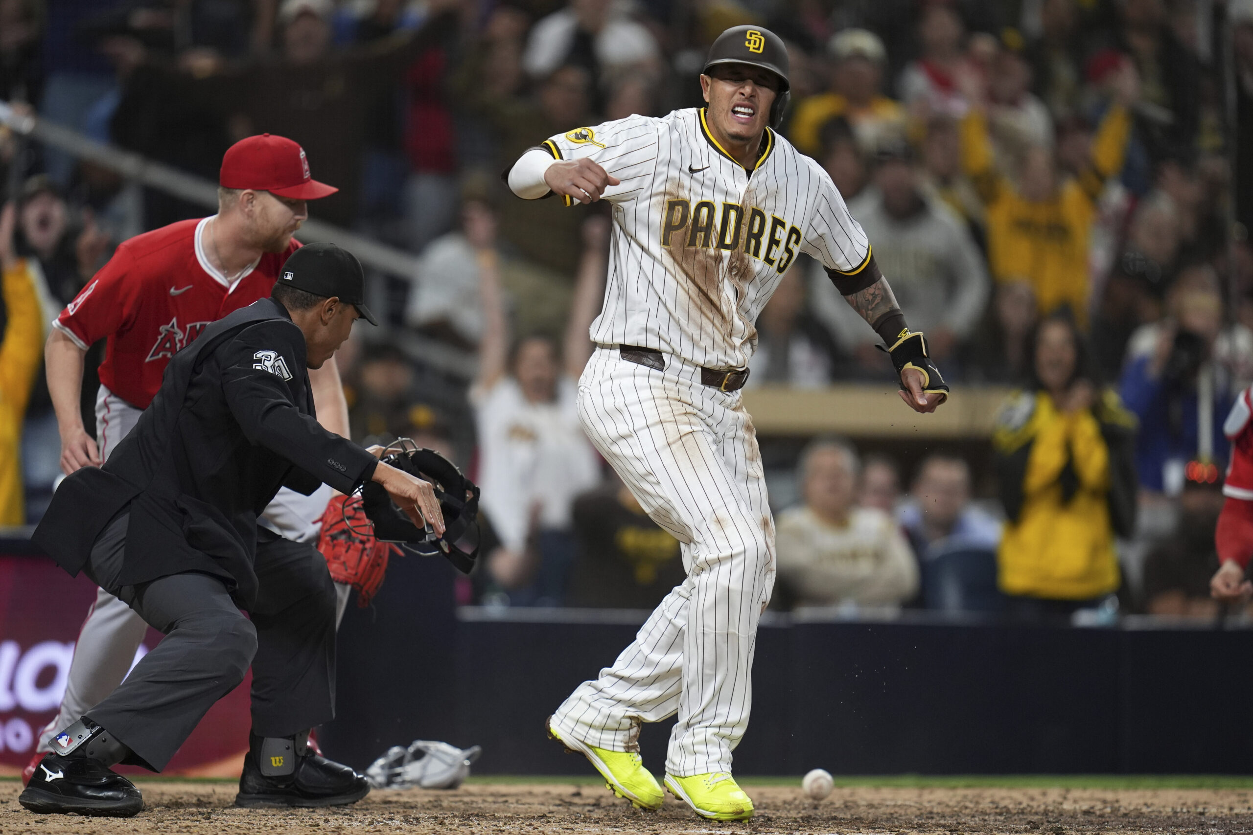 The San Diego Padres’ Manny Machado, center, celebrates after scoring...