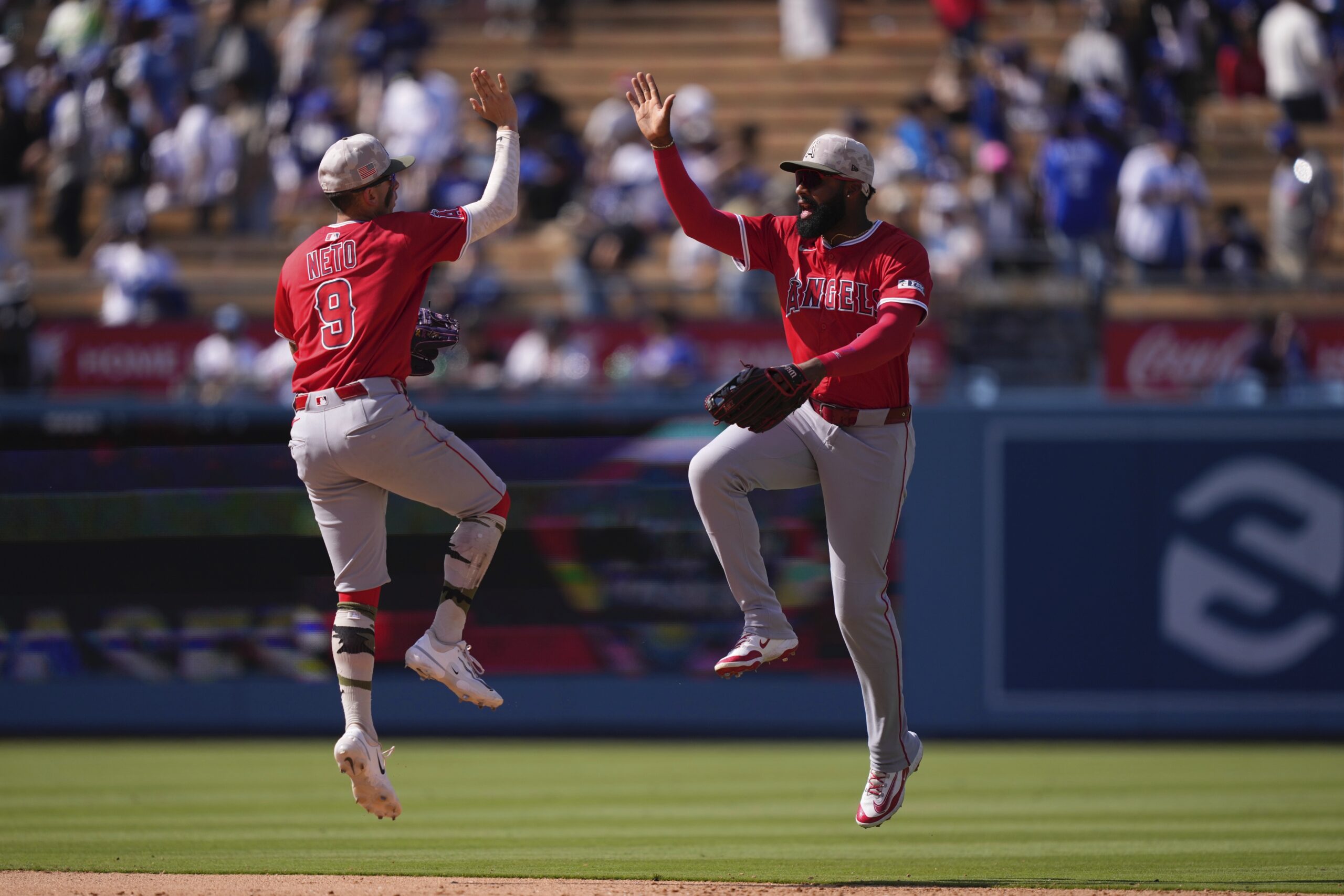Angels’ Zach Neto, left, and Jo Adell congratulate each other...