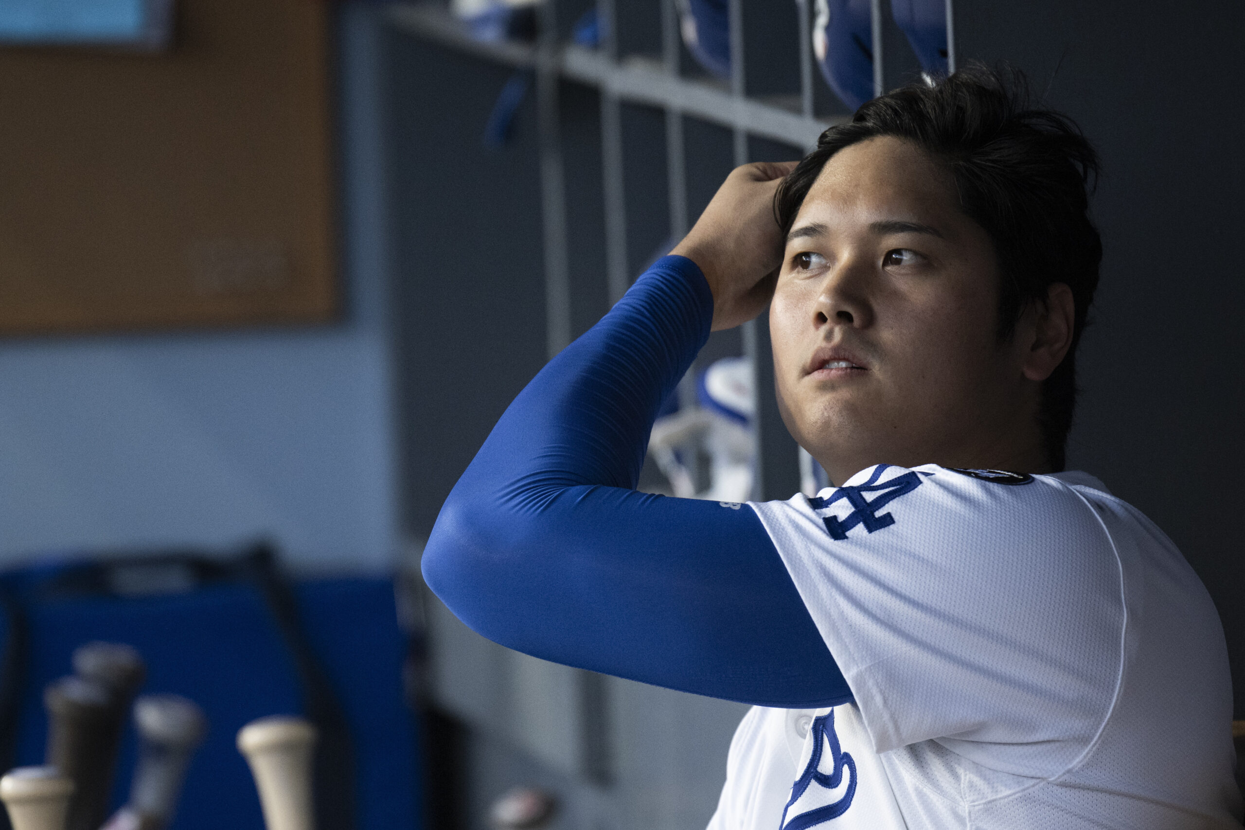 Dodgers’ Shohei Ohtani fixes his hair as he watches his...