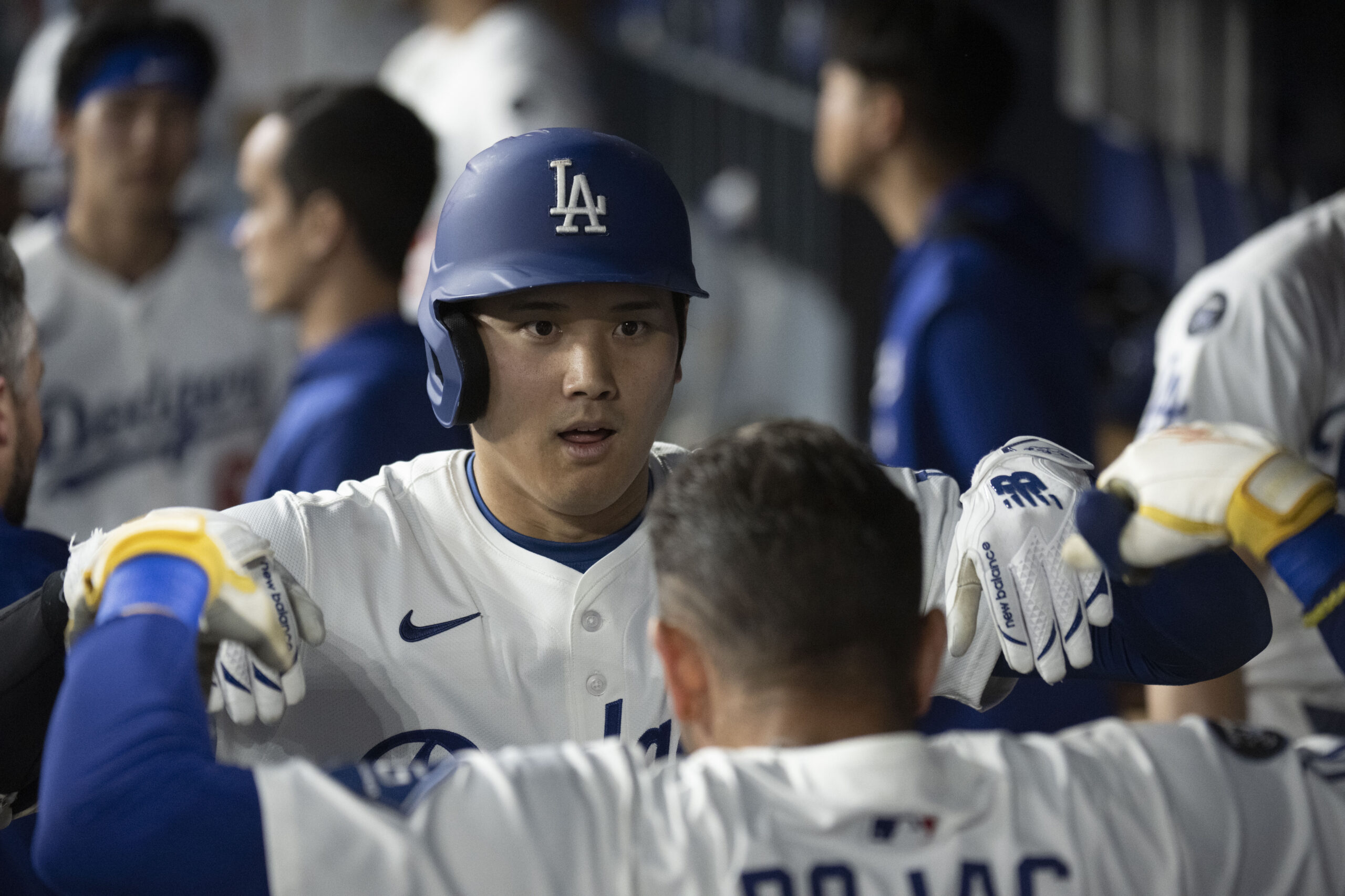 Dodgers’ Shohei Ohtani celebrates his solo home run with Miguel...
