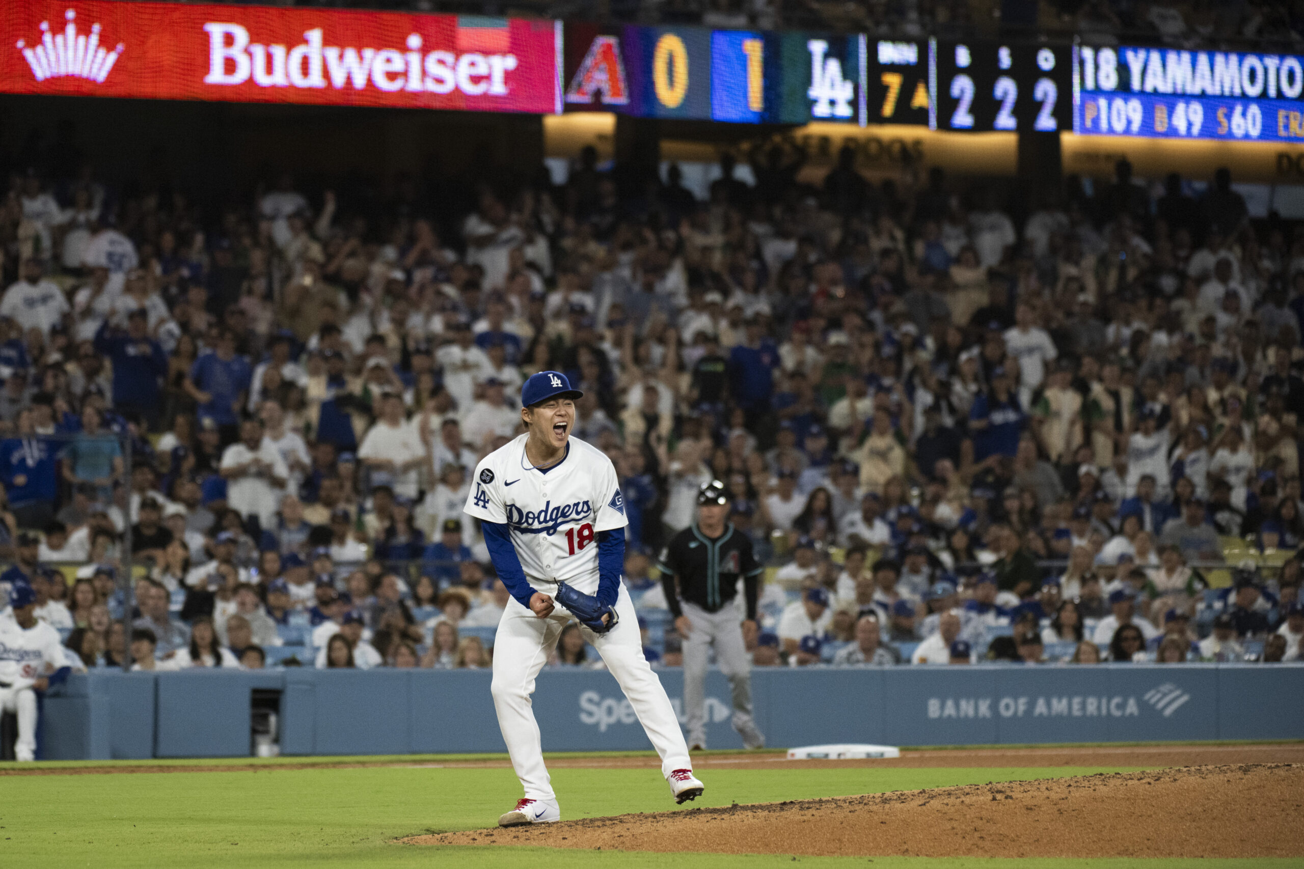 Dodgers starting pitcher Yoshinobu Yamamoto reacts after striking out Arizona...