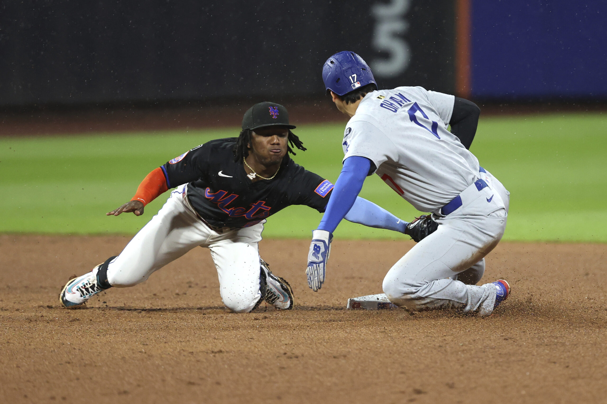 New York Mets second baseman Luisangel Acuña, left, tags out...