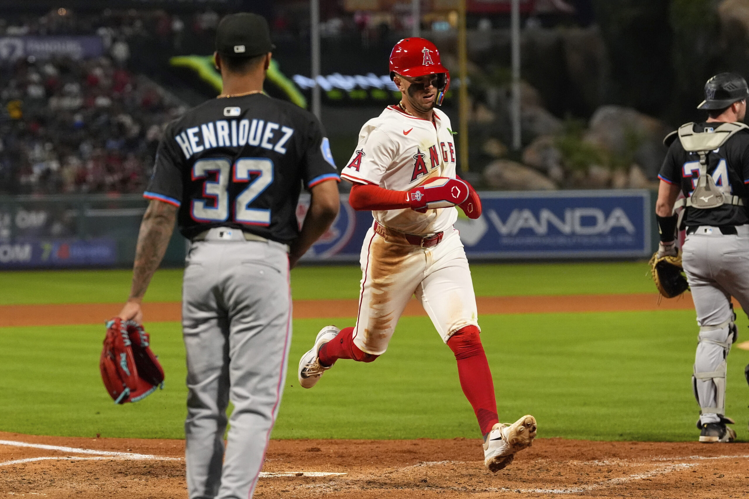 Angels’ Zach Neto, center, scores on a sacrifice fly by...