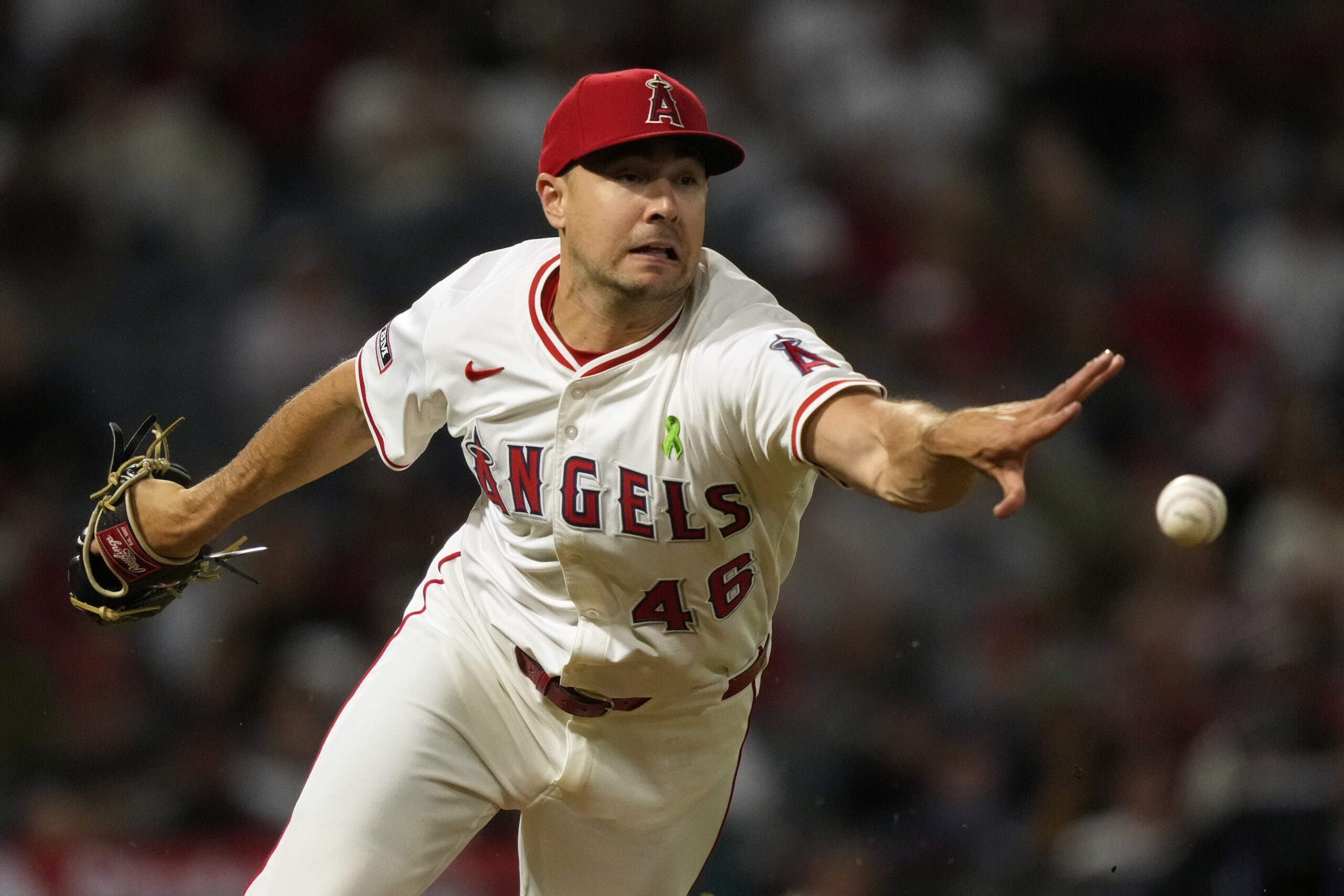 Angels relief pitcher Brock Burke flips the ball to first...