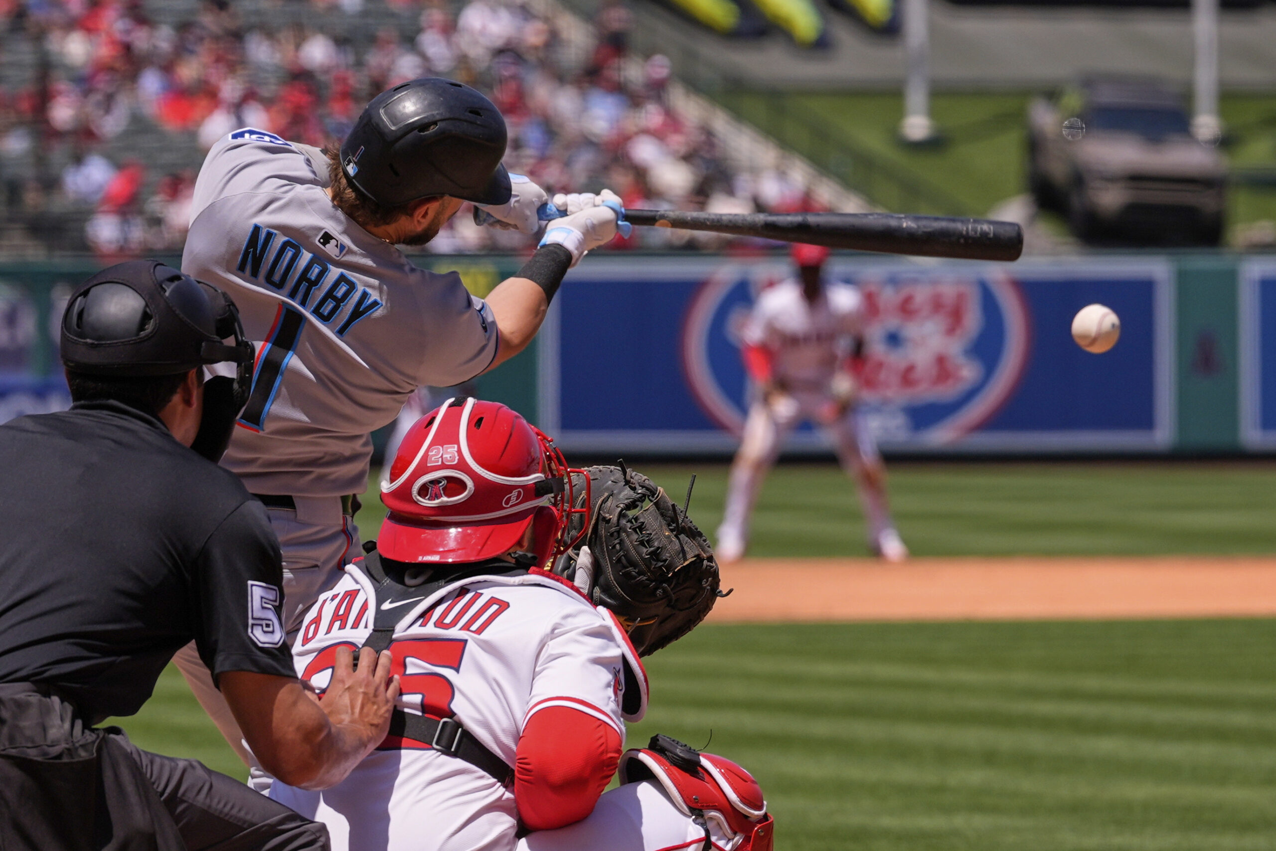 Miami Marlins’ Connor Norby, center, hits an RBI single as...