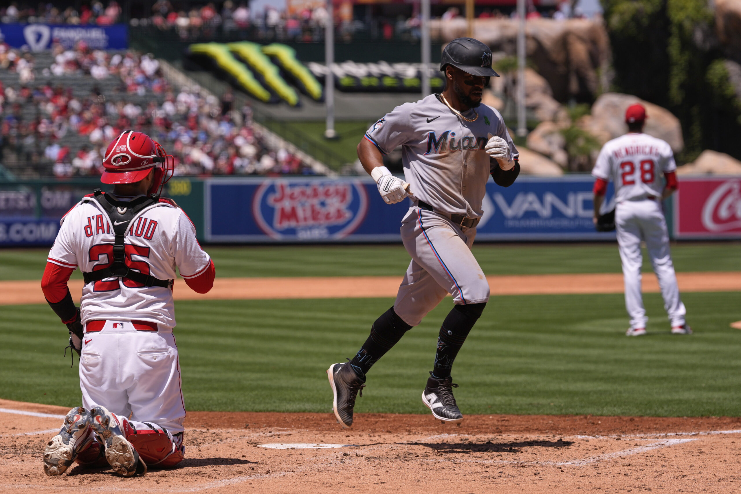 Miami Marlins’ Otto Lopez, right, scores on a single by...