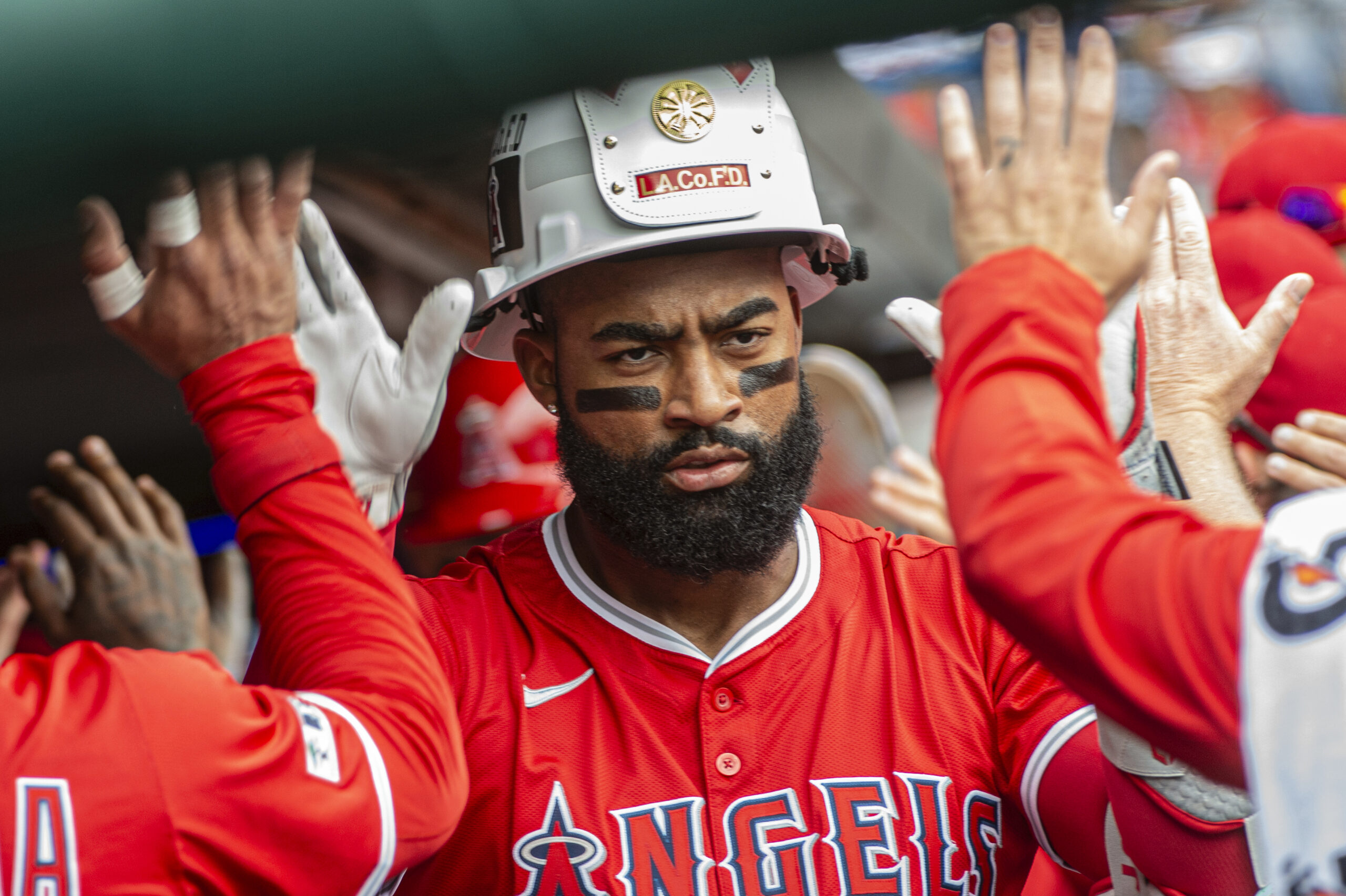 Angels’ Jo Adell is greeted by his teammates after hitting...