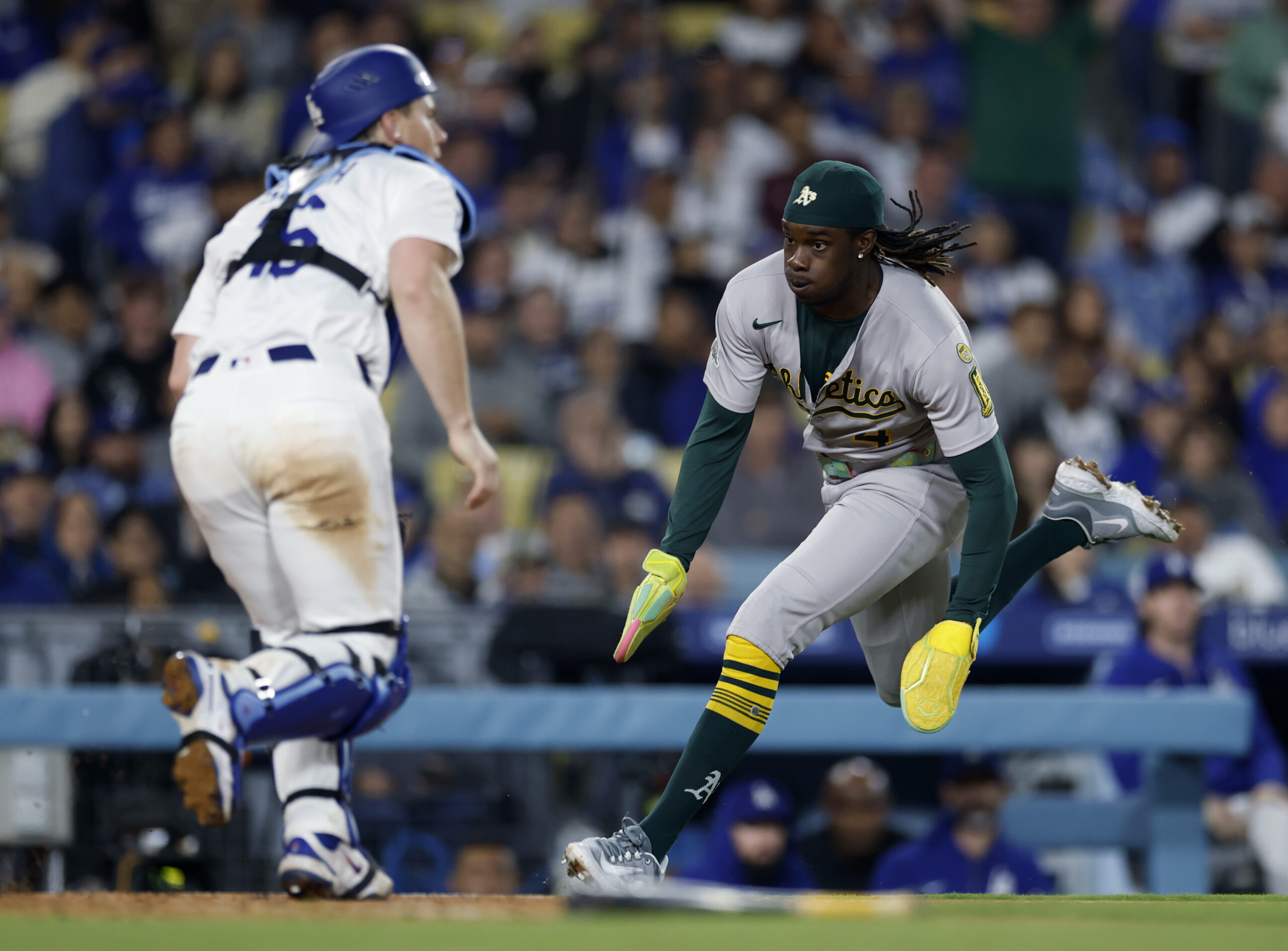 The Athletics’ Lawrence Butler, right, runs home to score in...