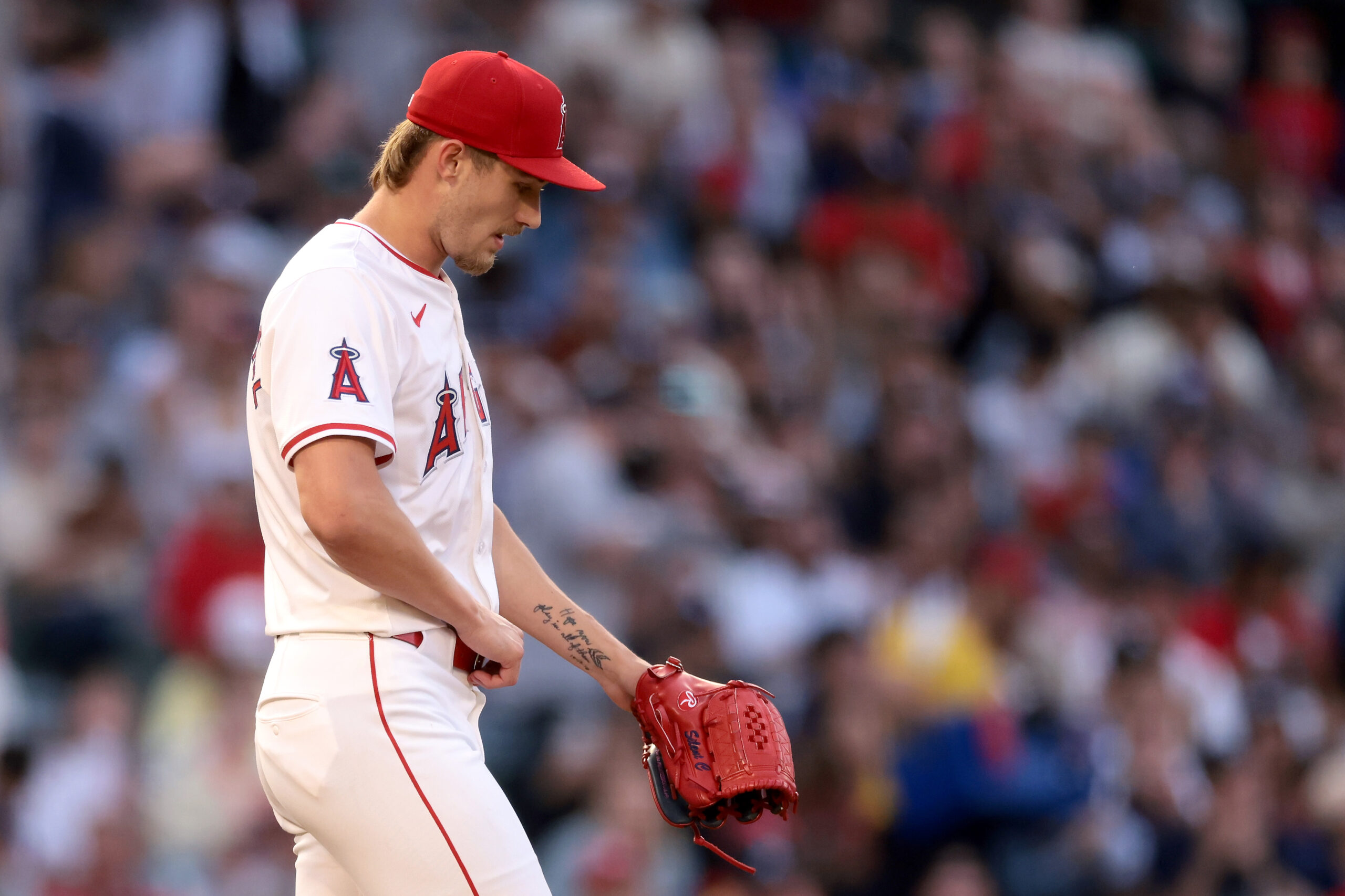 Angels starting pitcher Jack Kochanowicz reacts after walking in a...