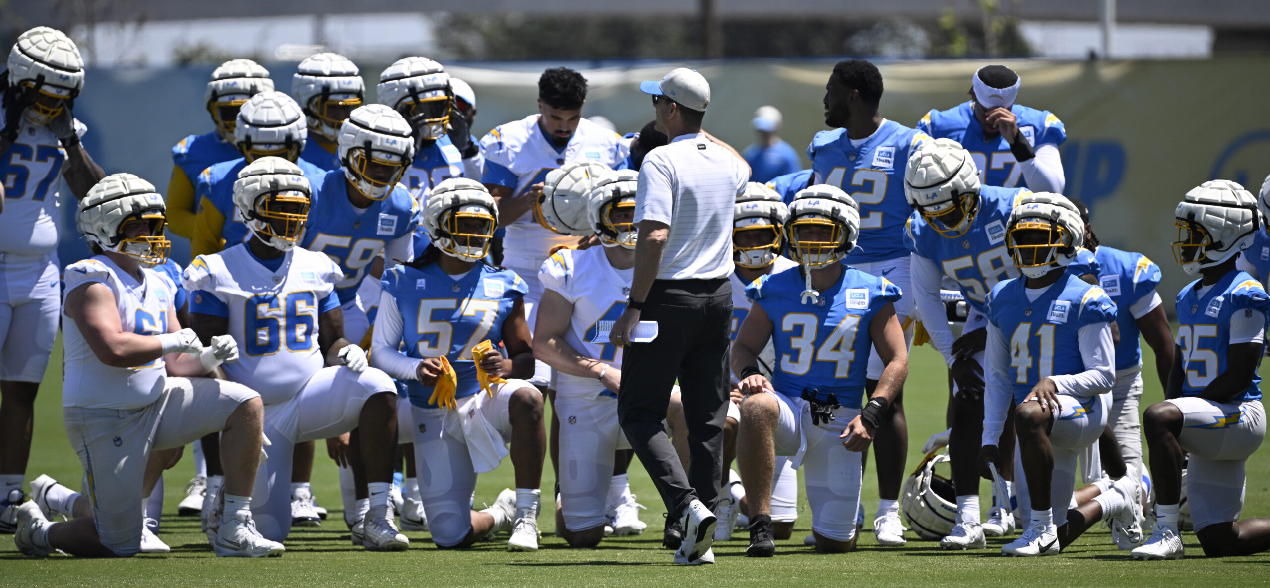 Chargers head coach Jim Harbaugh speaks to his team during...