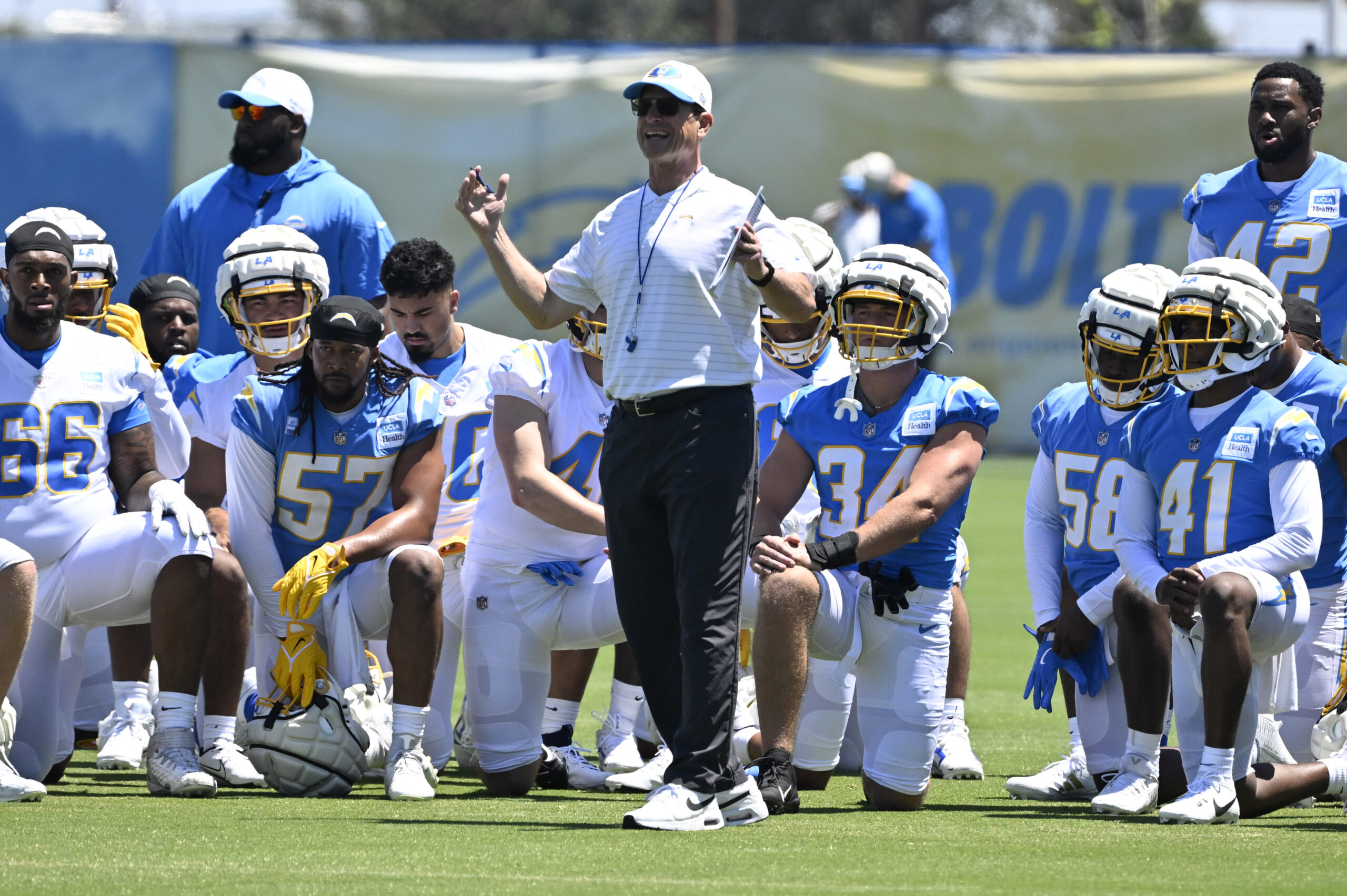 Chargers head coach Jim Harbaugh speaks to his team during...