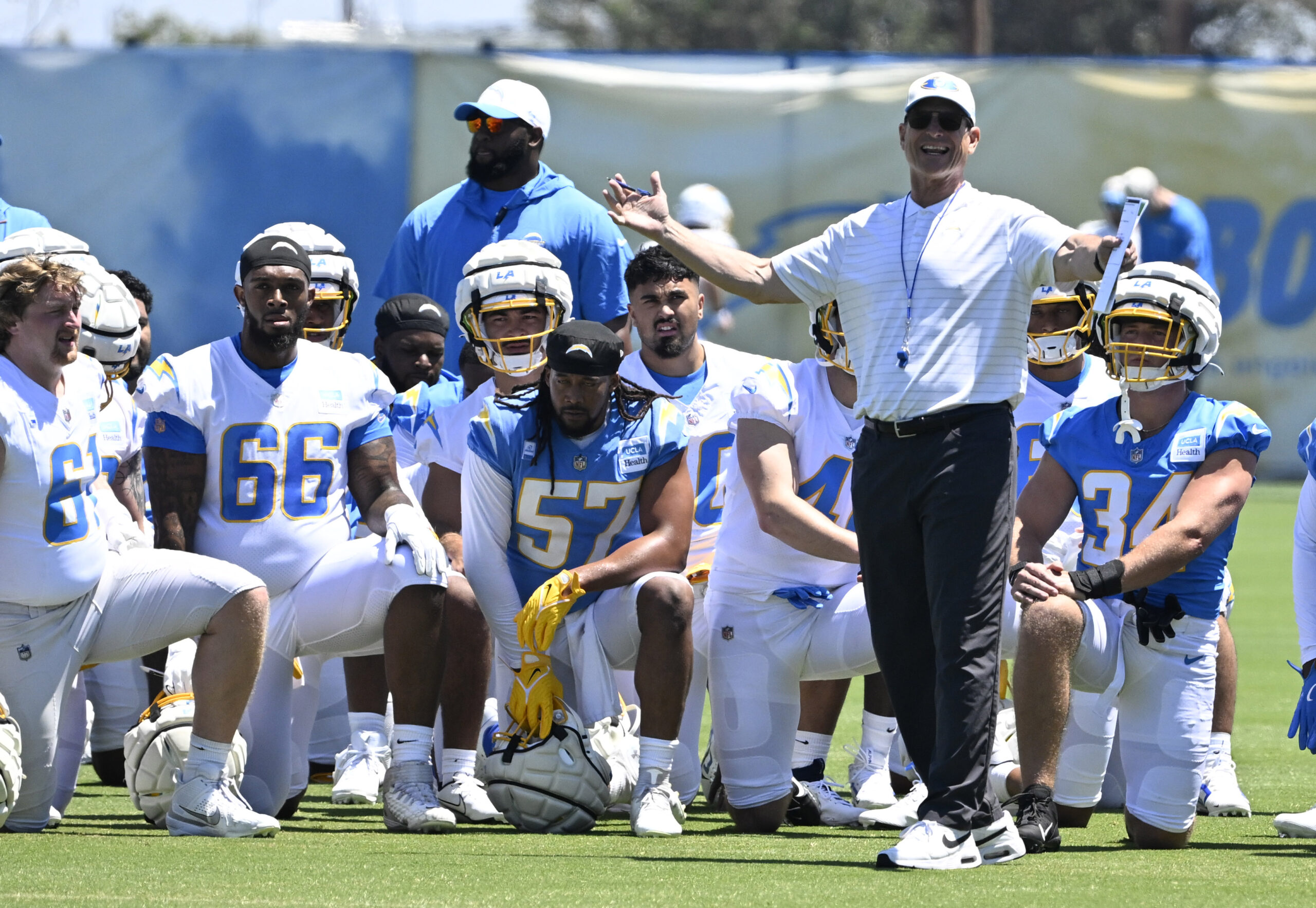 Chargers head coach Jim Harbaugh speaks to his team during...
