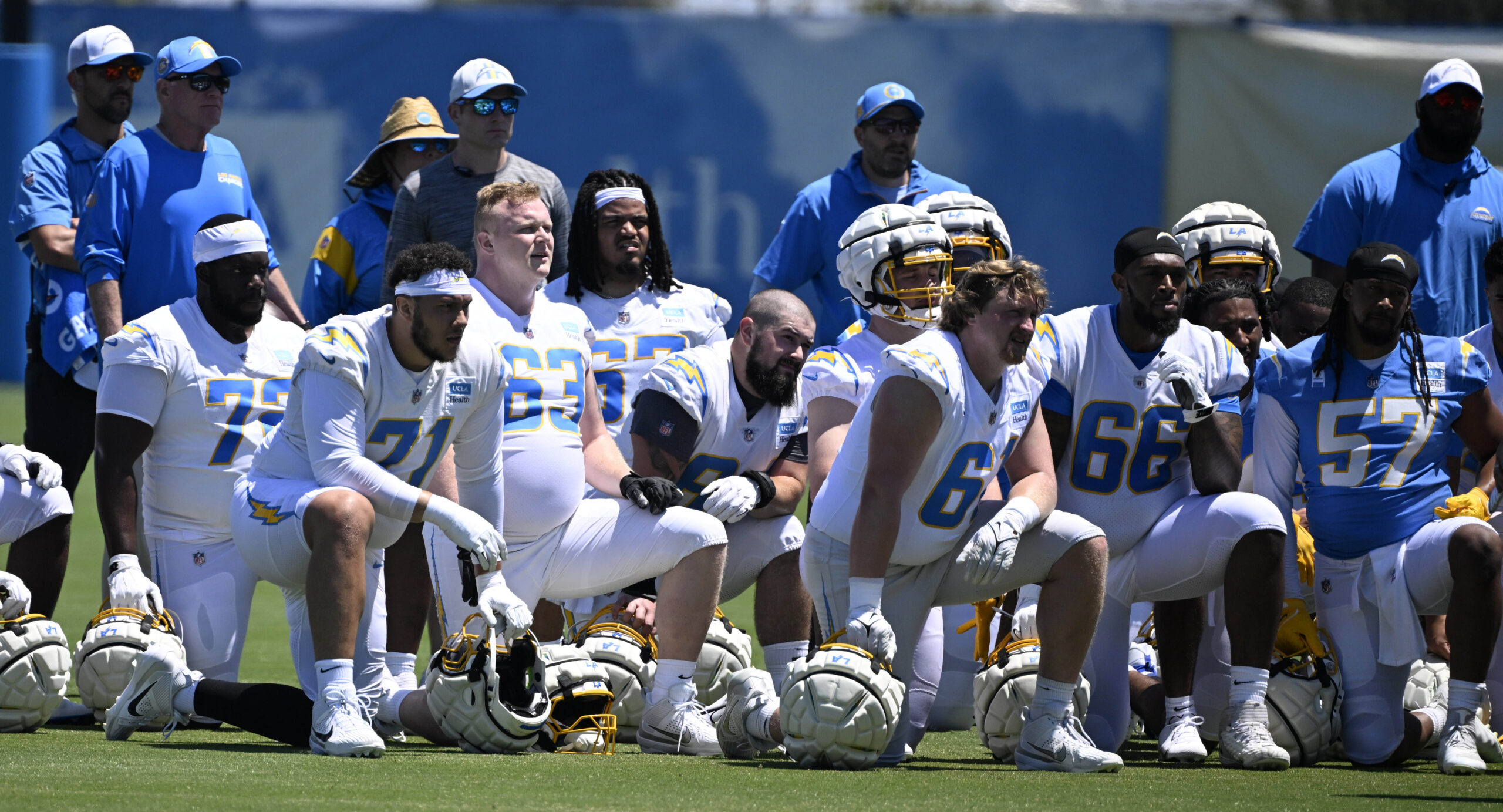 Chargers players listen to head coach Jim Harbaugh, not pictured,...