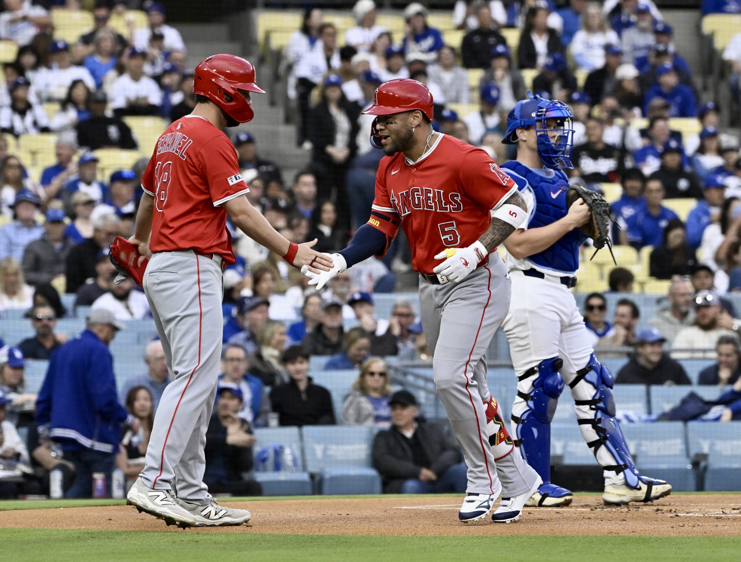 Yoan Moncada #5 of the Los Angeles Angels high fives...