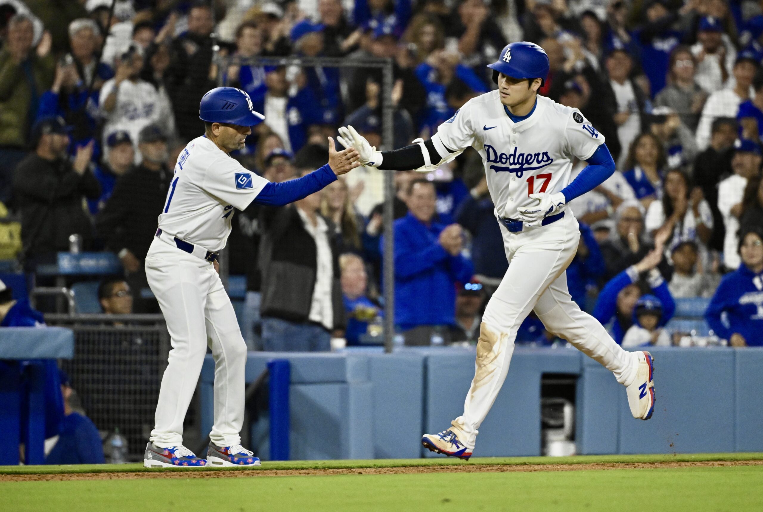 Shohei Ohtani #17 of the Los Angeles Dodgers high fives...