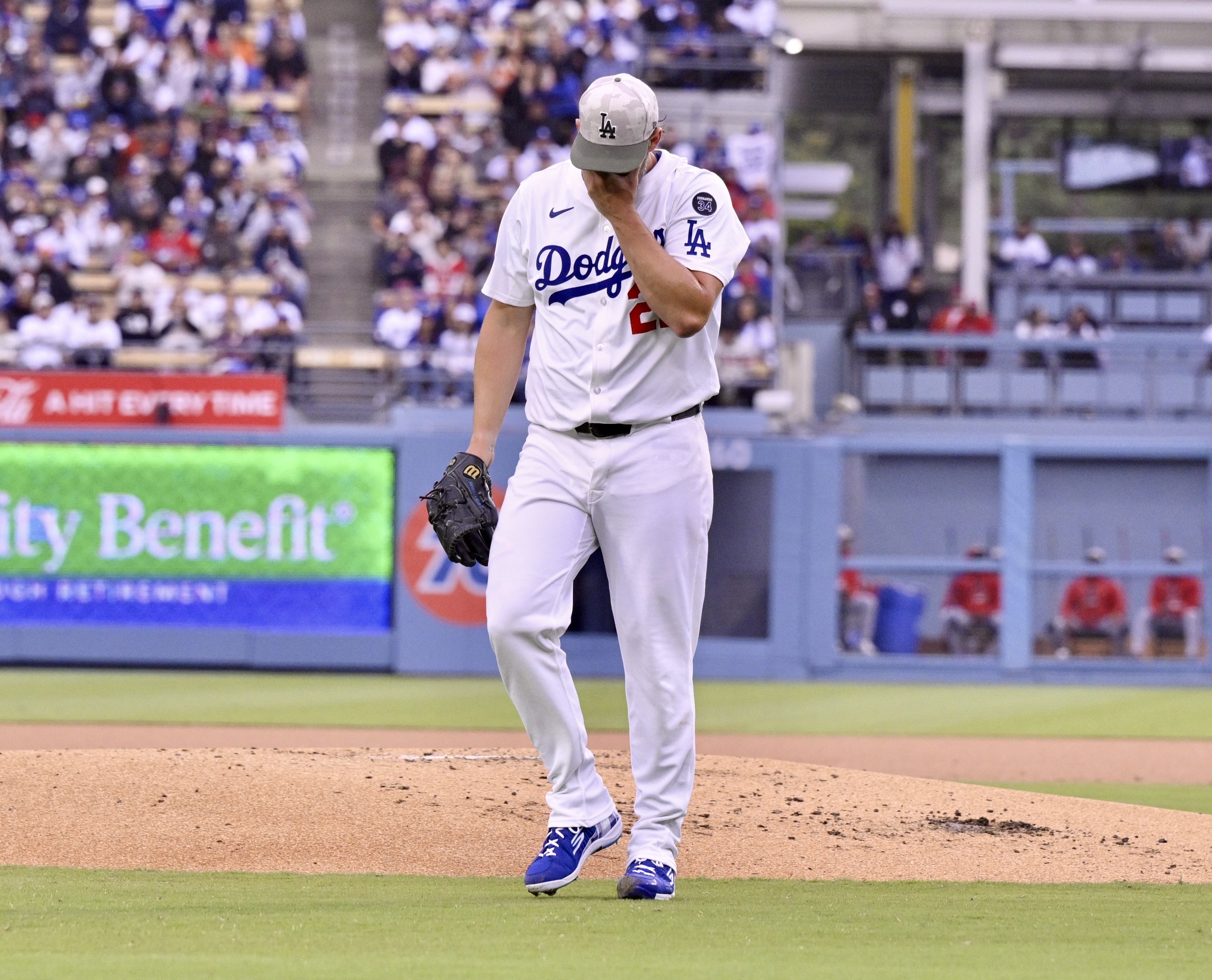 Starting pitcher Clayton Kershaw #22 of the Dodgers wipes his...