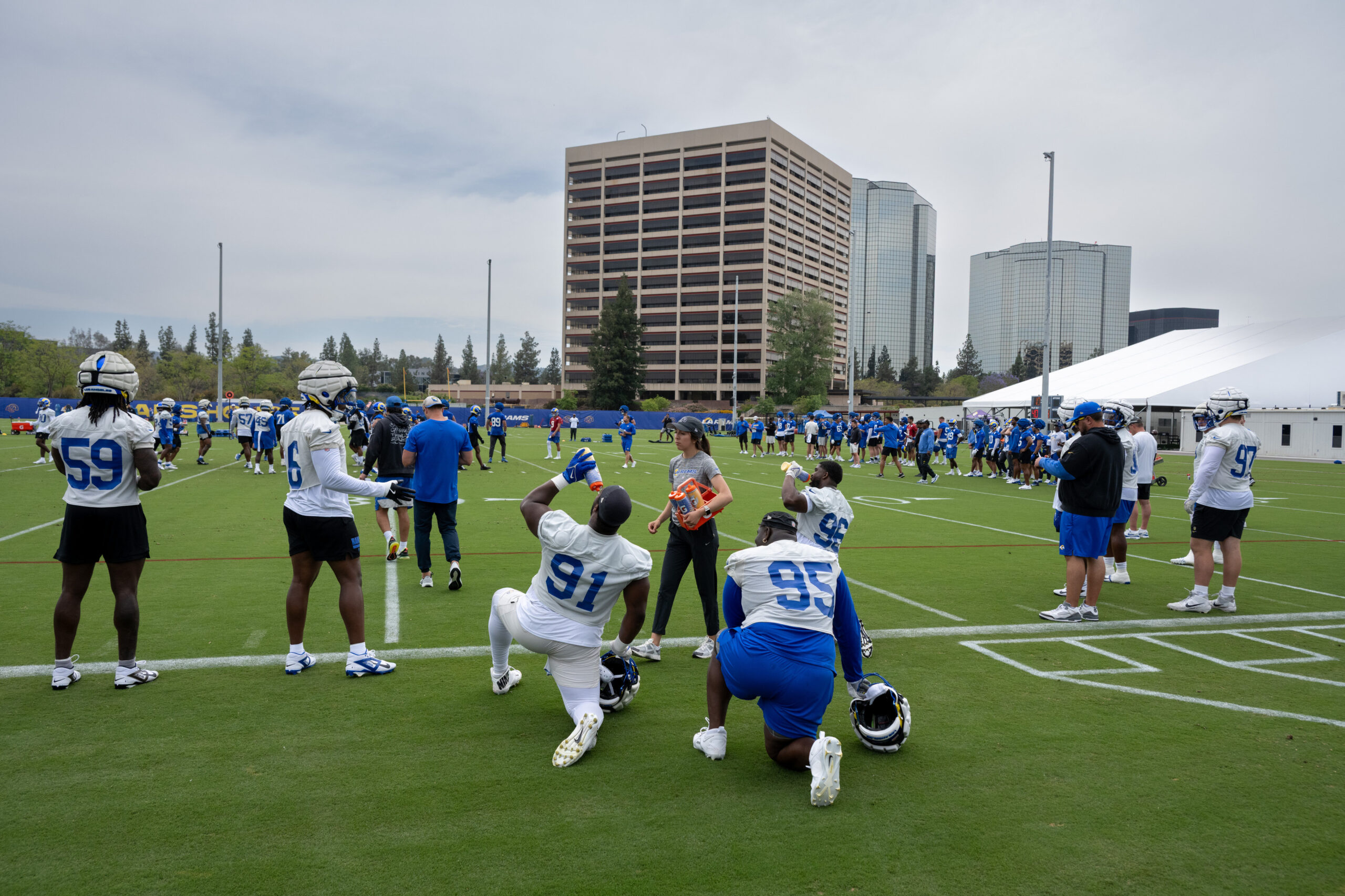 Rams players take the field during an OTA workout on...
