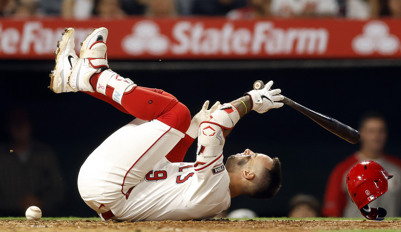 The Angels’ Zach Neto falls to the ground after being...