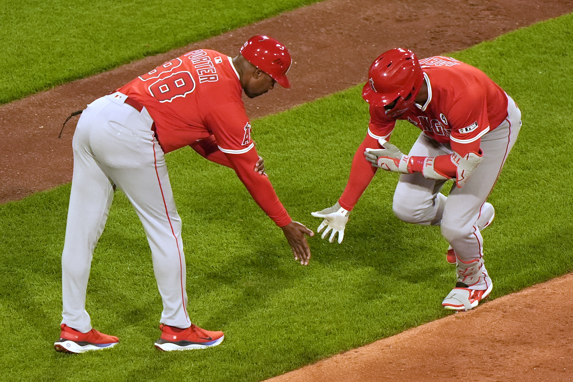 The Angels’ Jo Adell, right, is congratulated by third base...