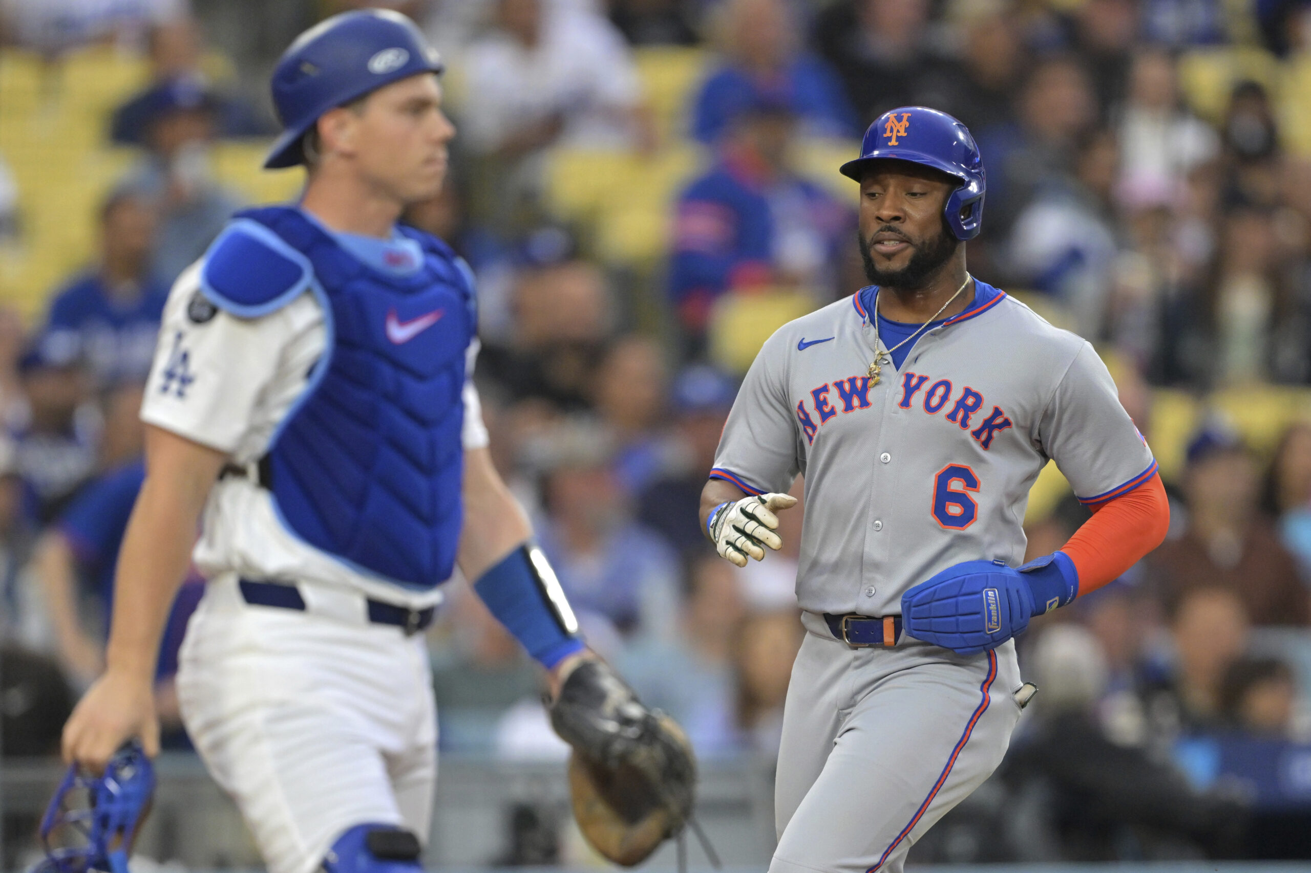 The New York Mets’ Starling Marte, right, scores past Dodgers...