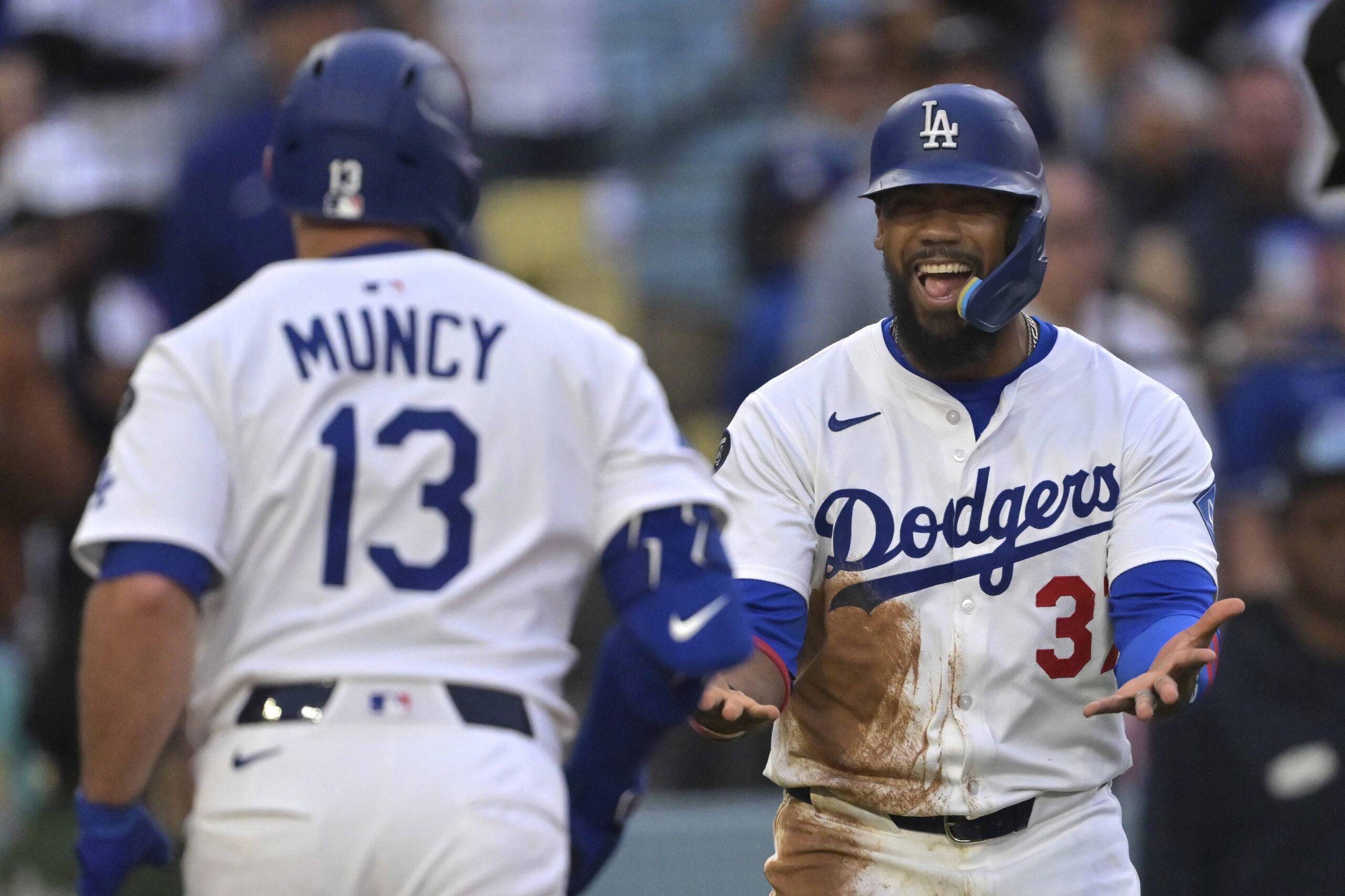 The Dodgers’ Max Muncy, left, is greeted by teammate Teoscar...