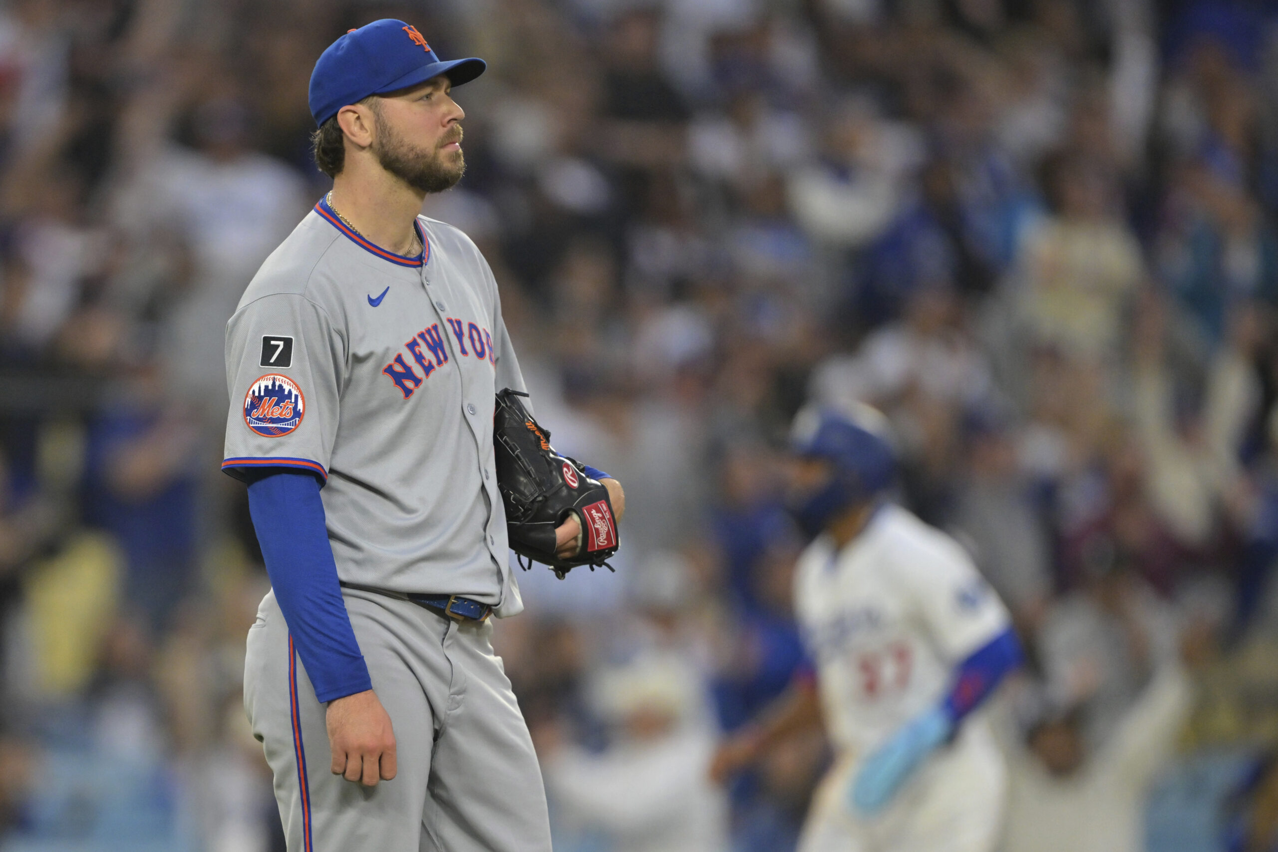 New York Mets starting pitcher Tylor Megill looks on after...