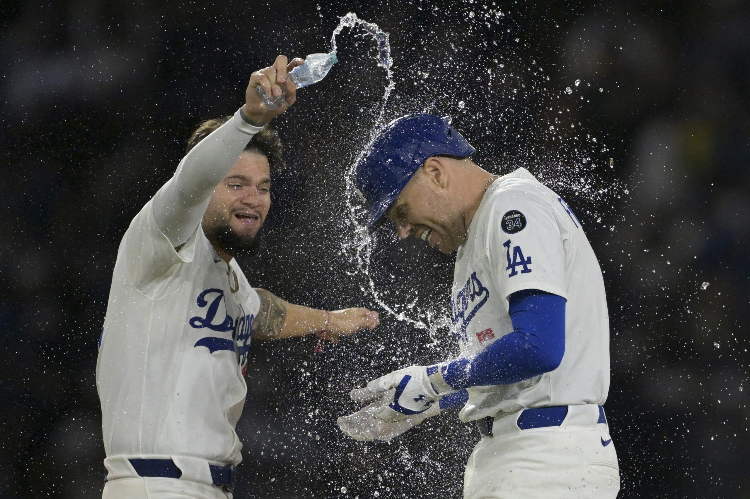 The Dodgers’ Freddie Freeman, right, is doused with water by...