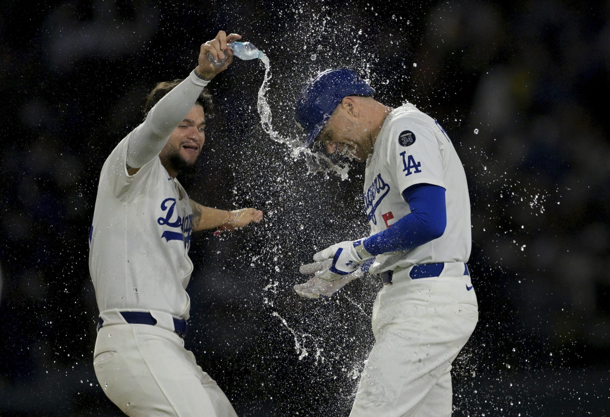 The Dodgers’ Freddie Freeman, right, is doused with water by...