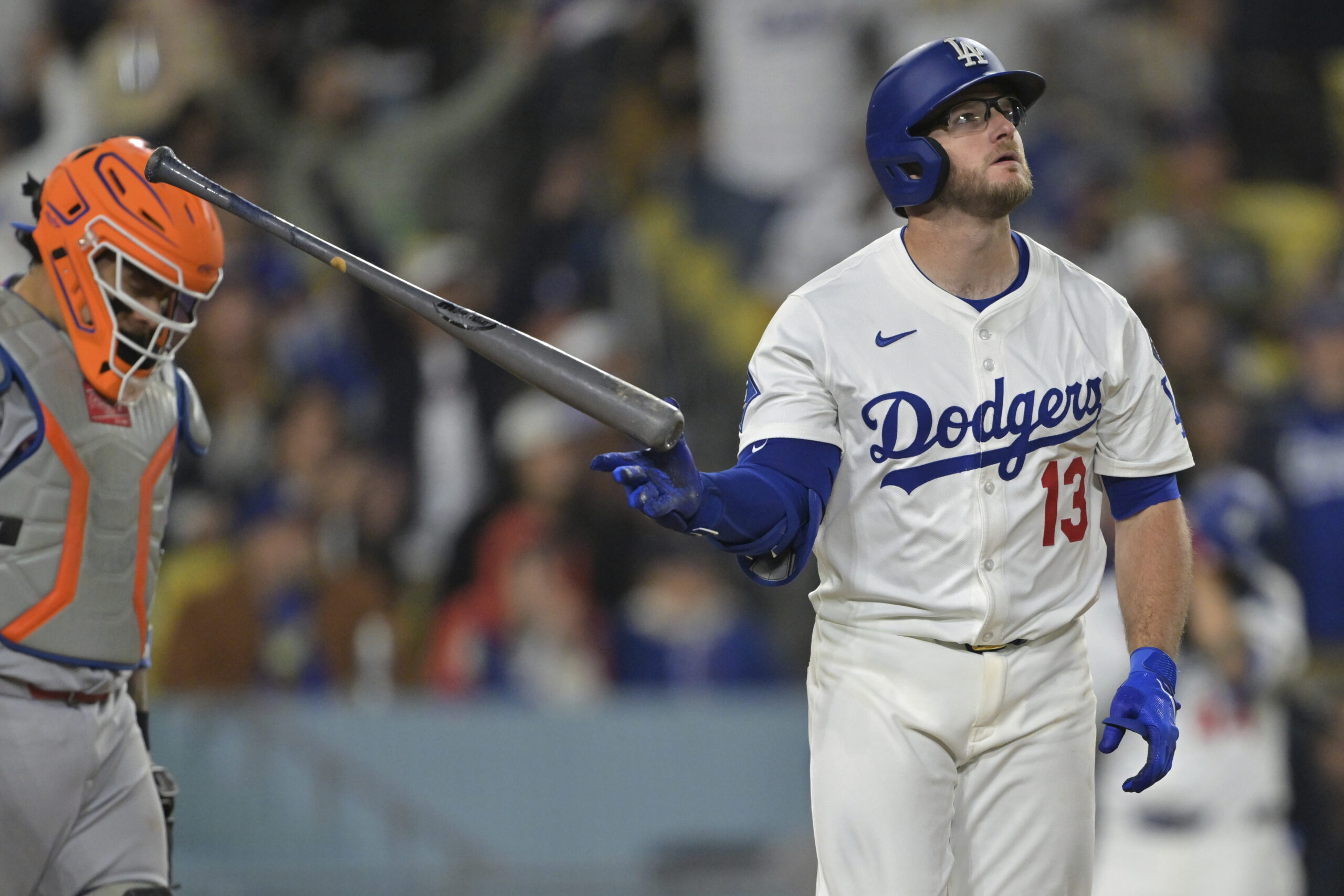 The Dodgers’ Max Muncy tosses his bat as he watches...