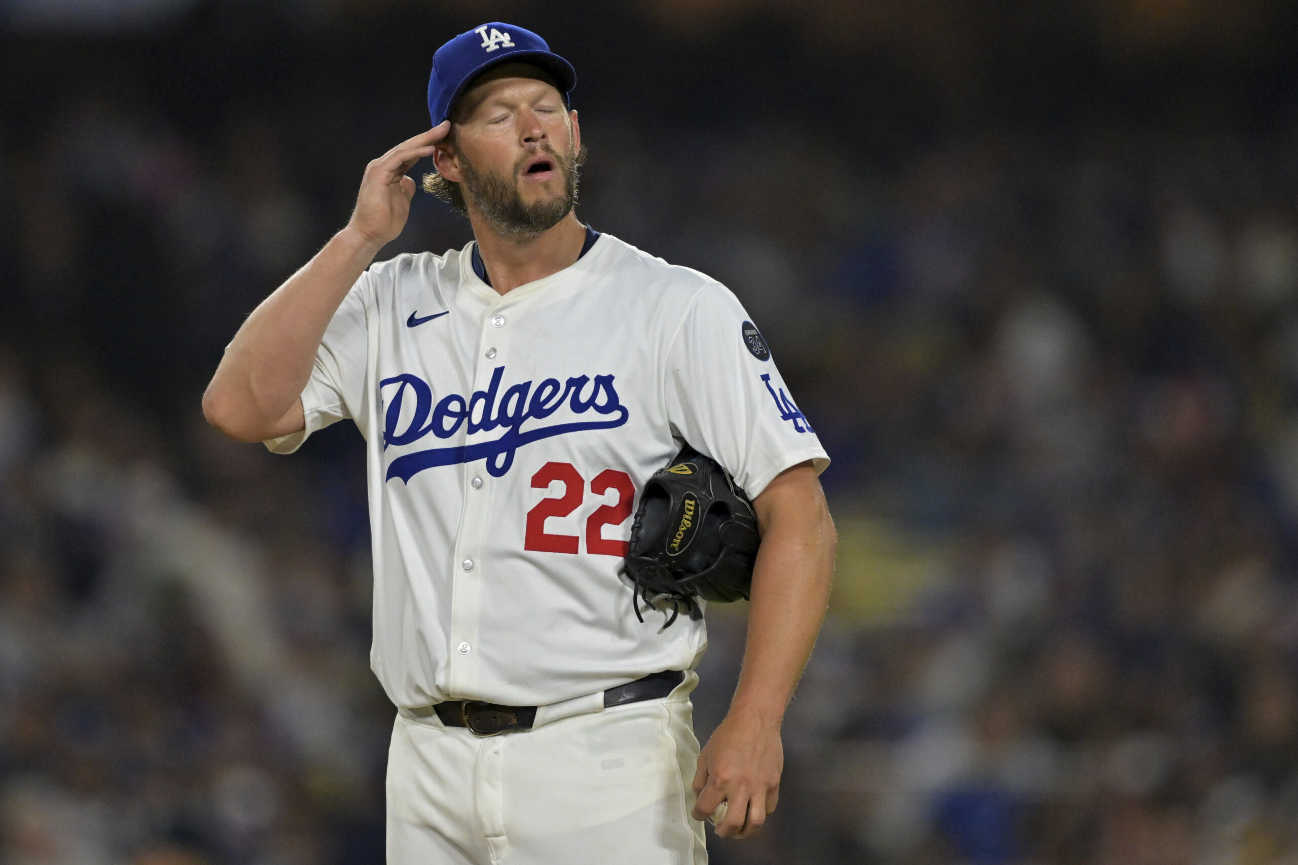 Dodgers starting pitcher Clayton Kershaw reacts after giving up a...
