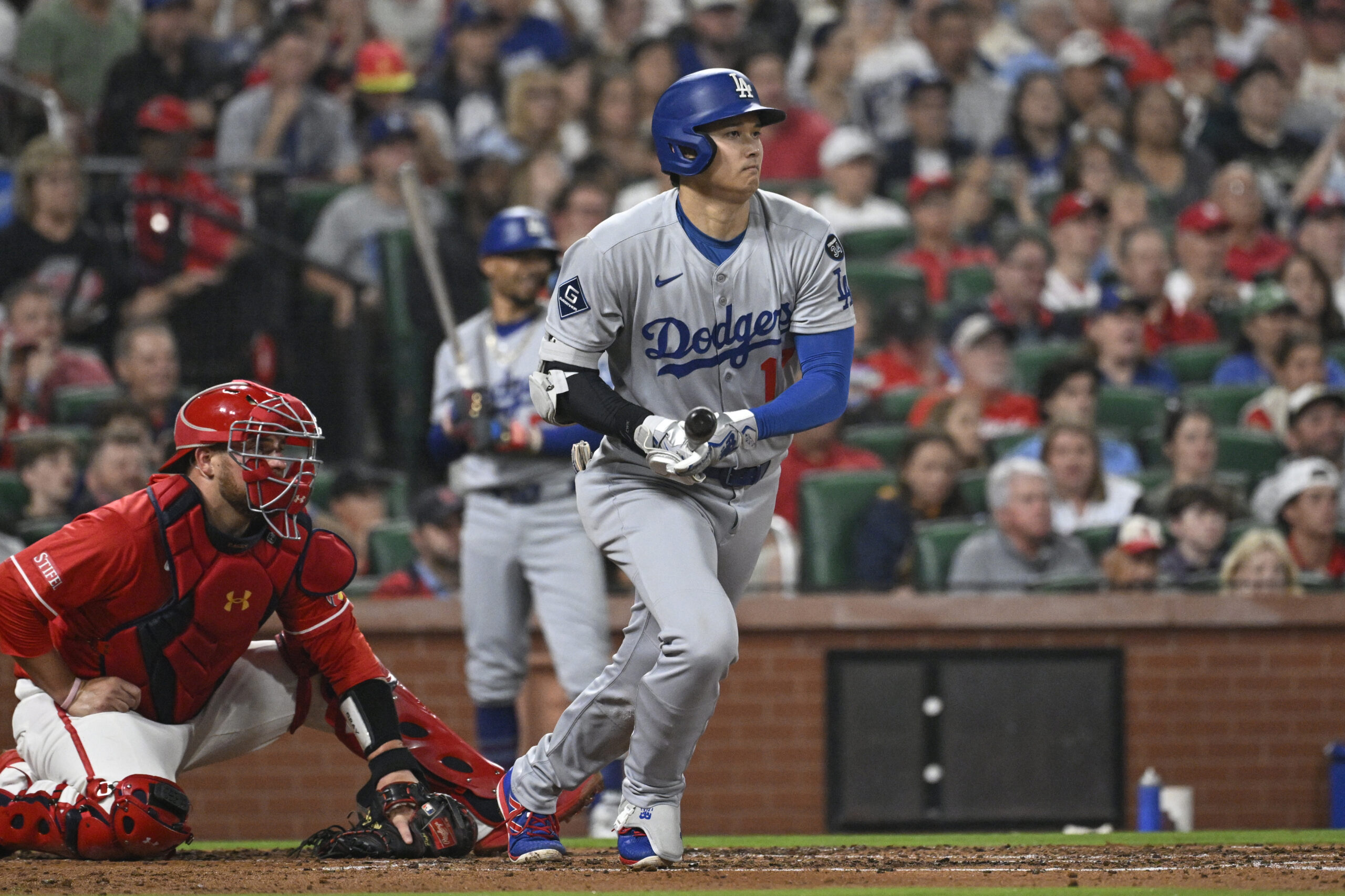 Dodgers star Shohei Ohtani begins to run after hitting a...