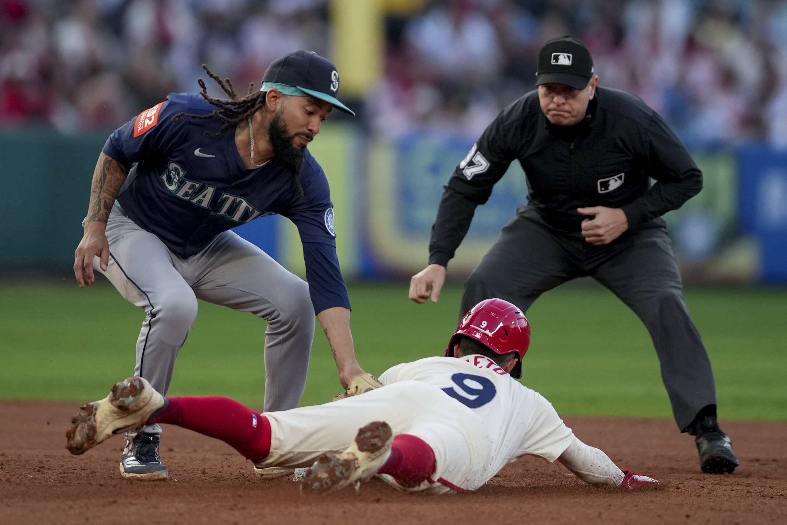 Seattle Mariners shortstop J.P. Crawford, left, tags the Angels’ Zach...