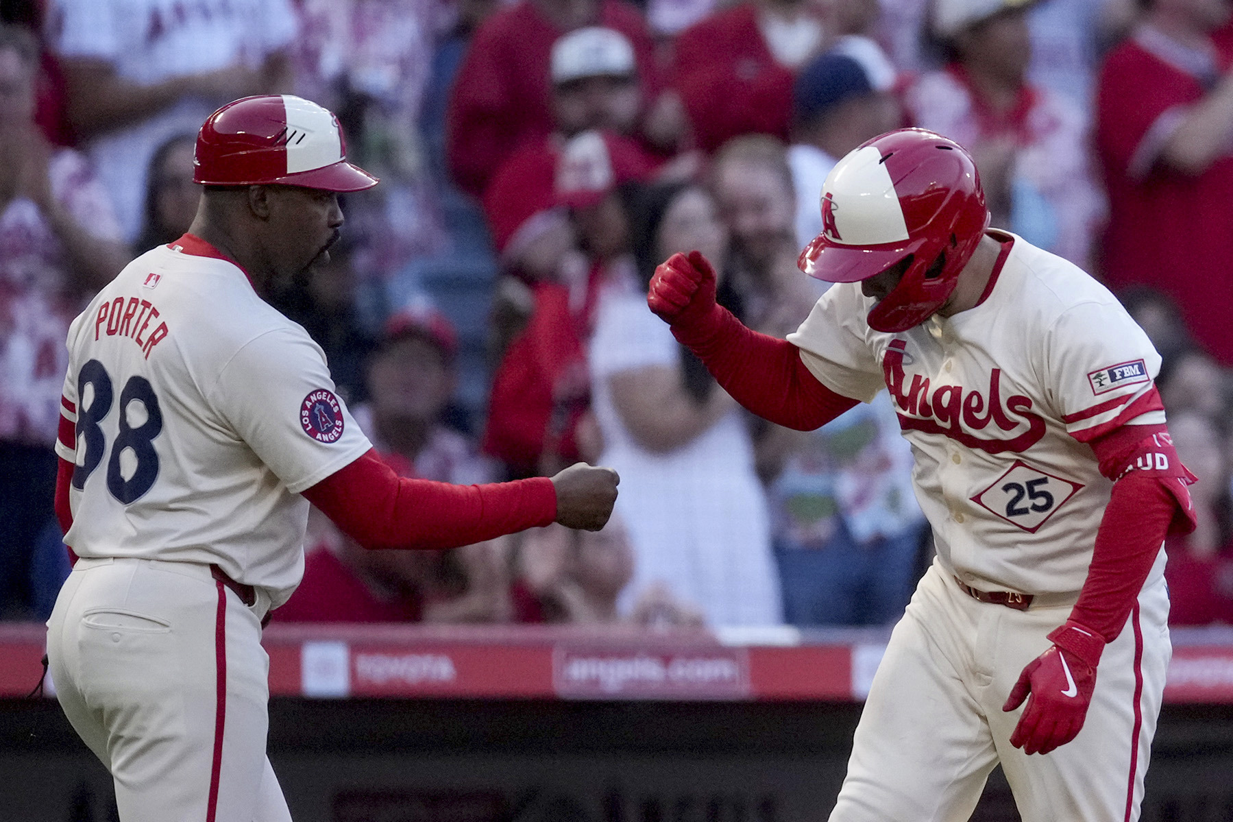 The Angels’ Travis d’Arnaud, right, celebrates with third base coach...