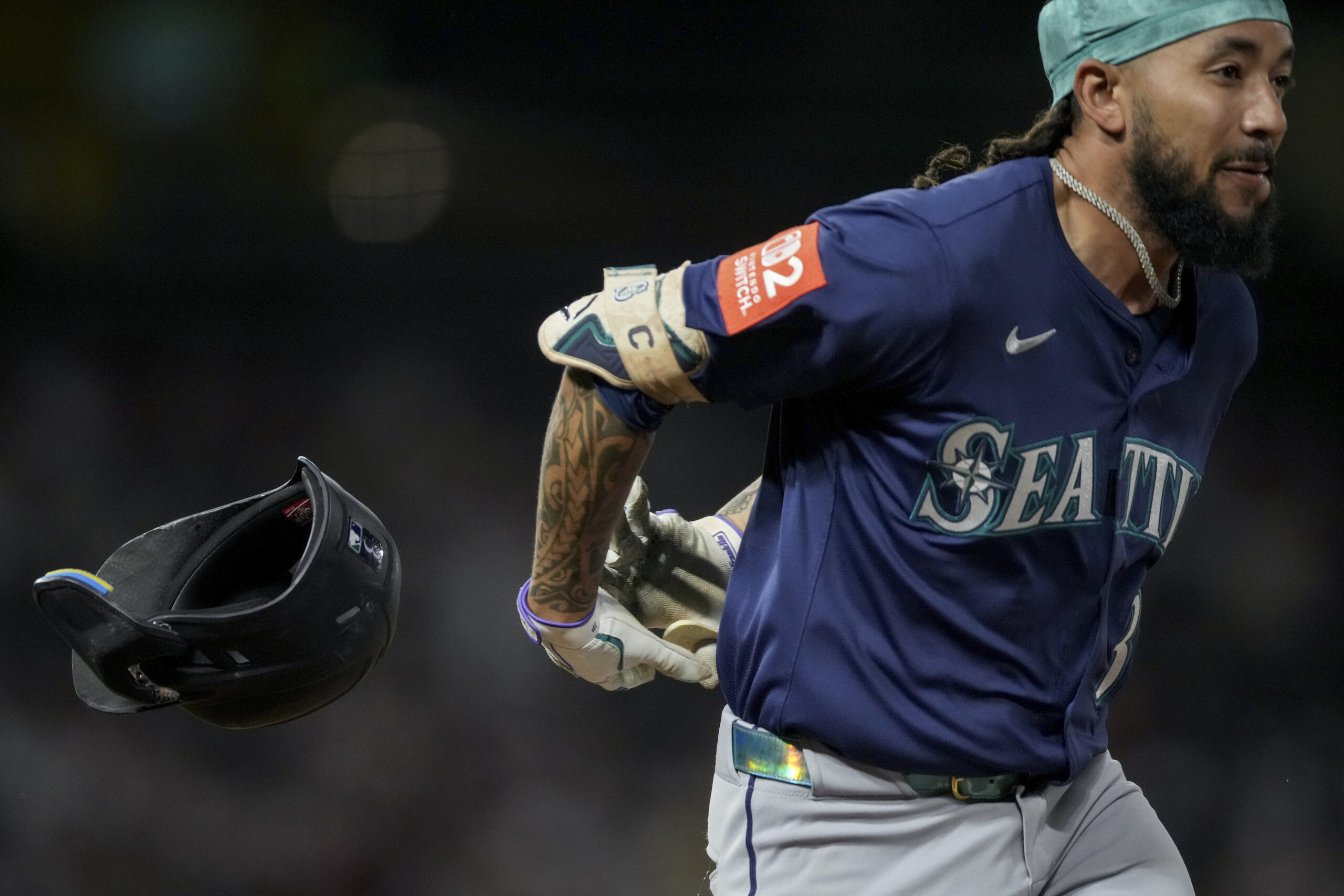 The Seattle Mariners’ J.P. Crawford loses his helmet while running...