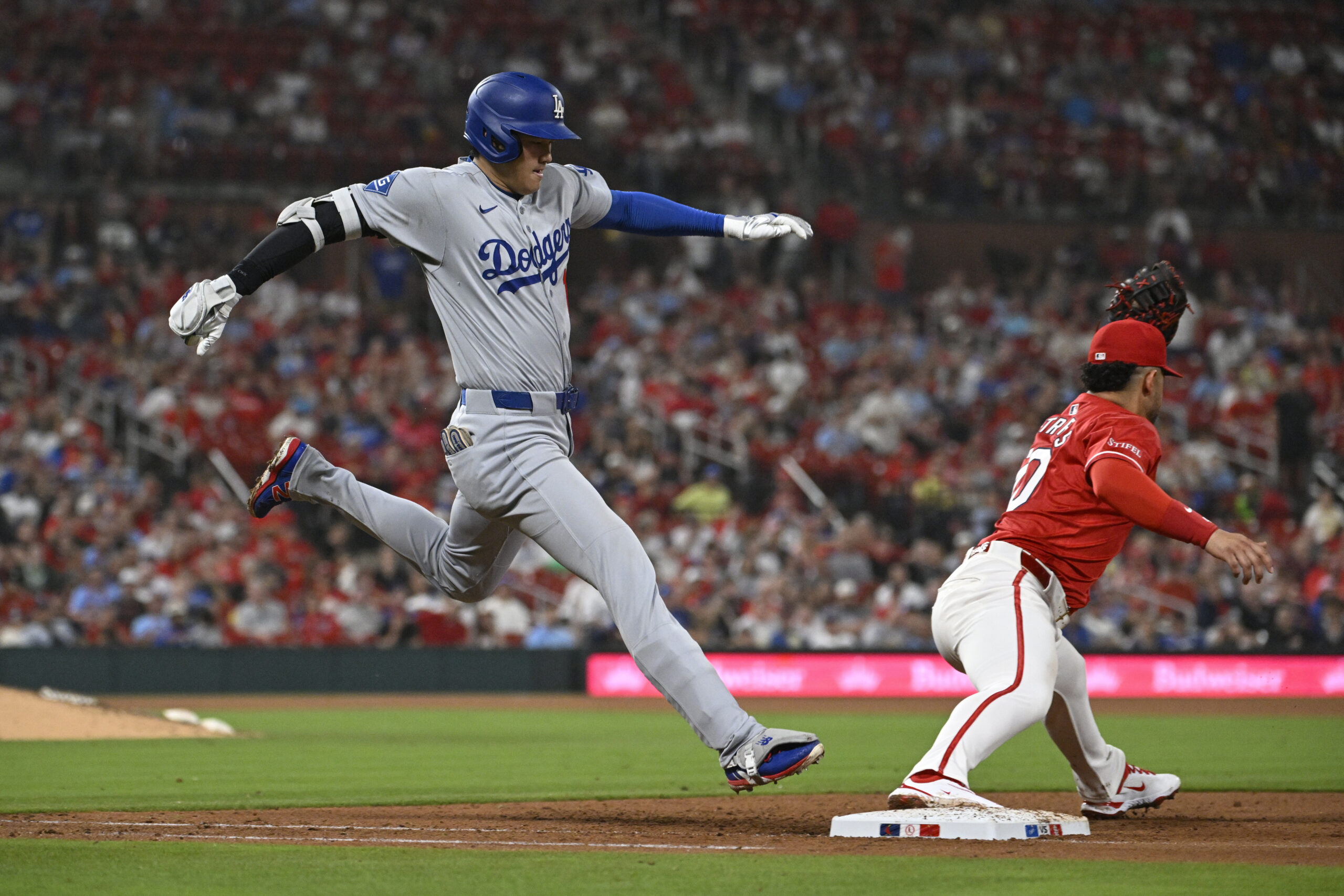Dodgers star Shohei Ohtani, left, can’t beat the throw to...