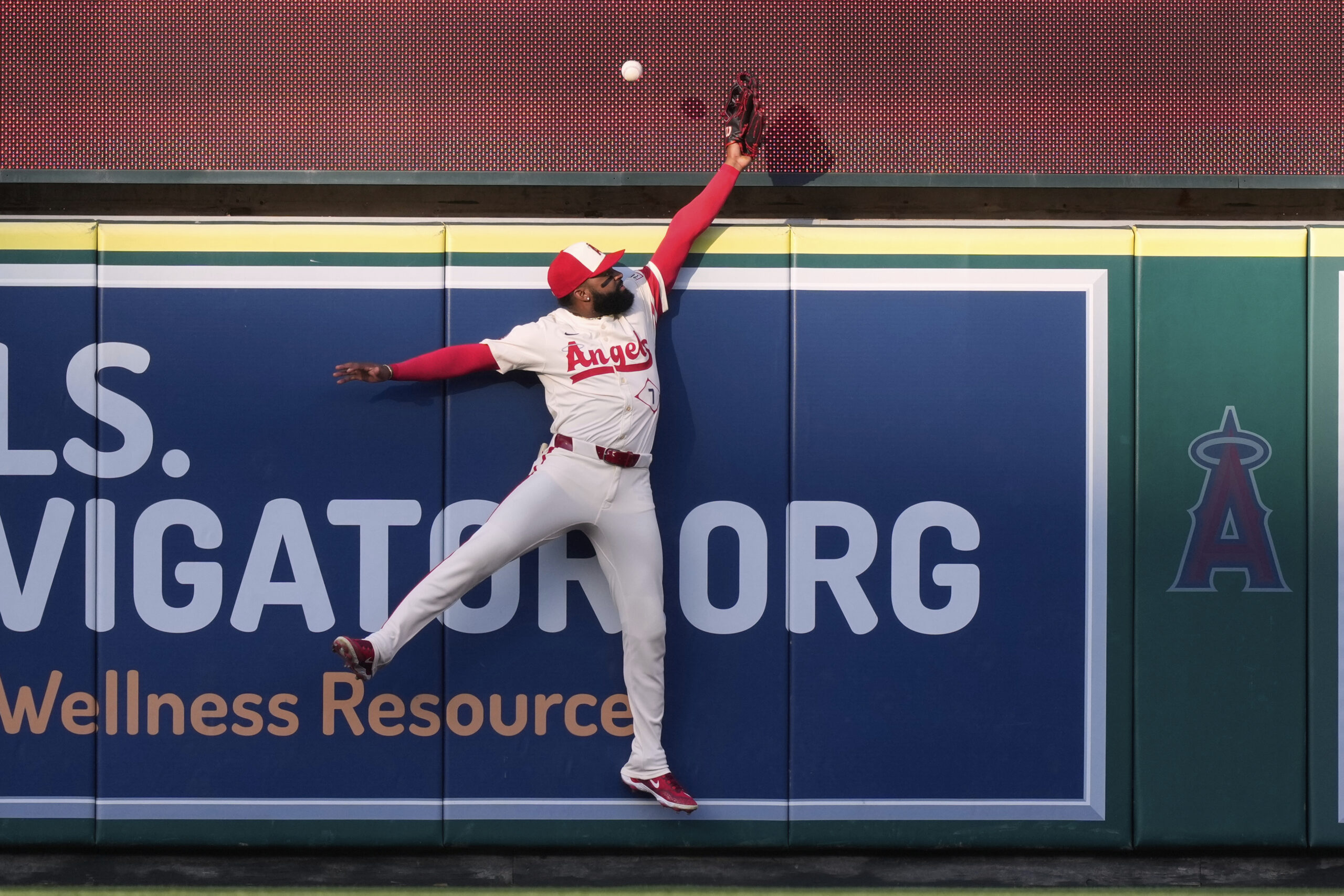 Angels center fielder Jo Adell can’t reach a ball hit...
